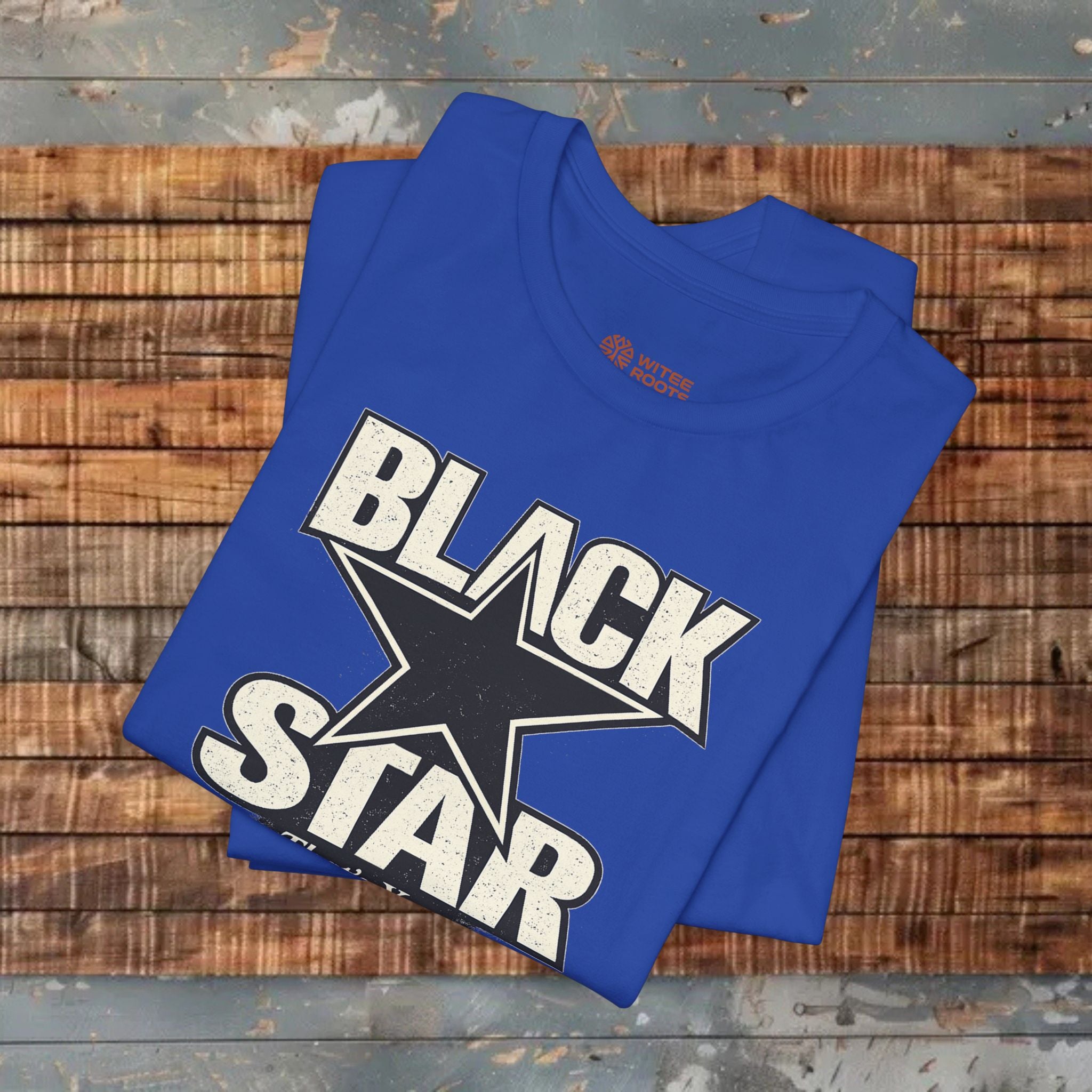 Blue t-shirt with 'Black Star' design on a wooden surface