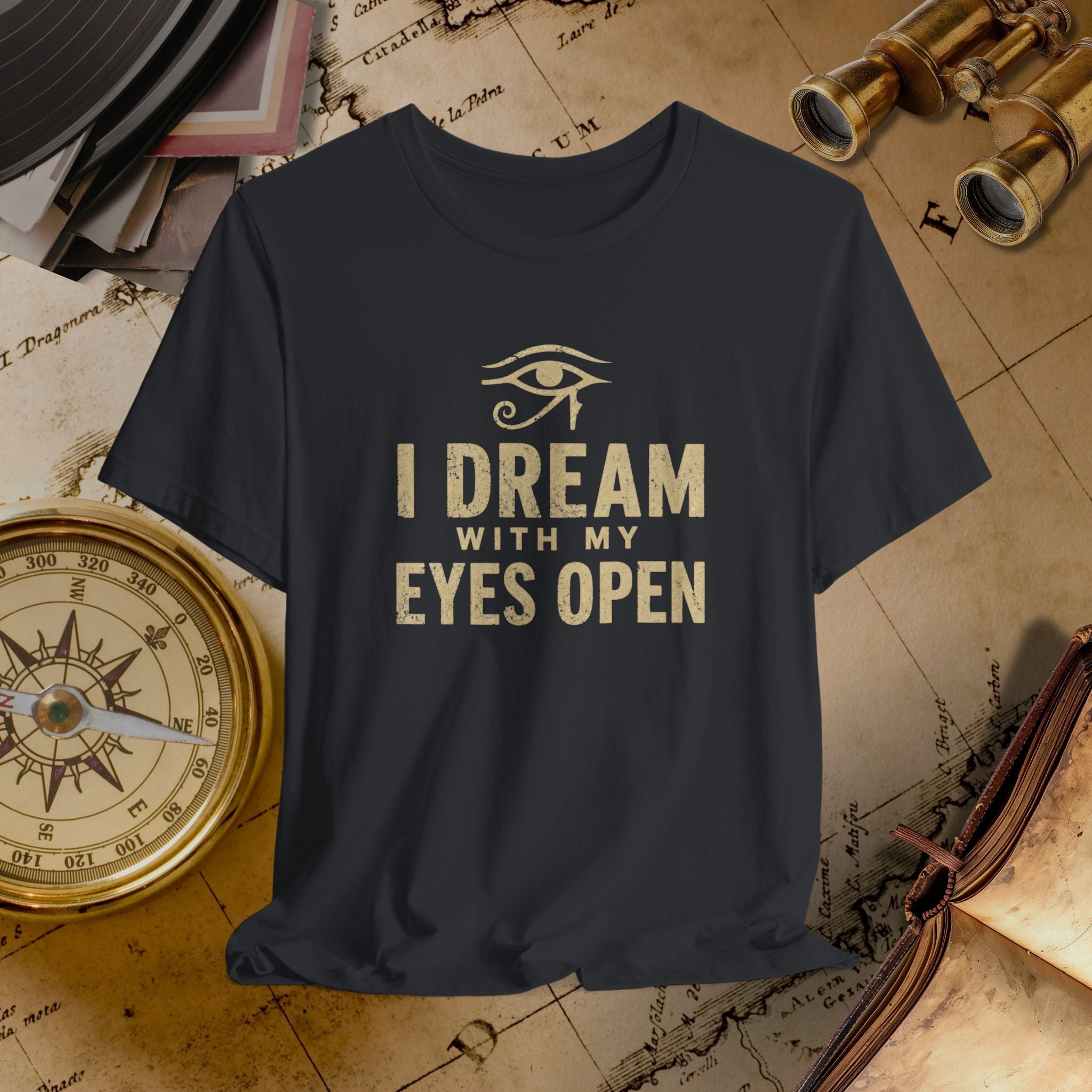 Black t-shirt with 'I Dream with My Eyes Open' text and eye symbol on a vintage map background.