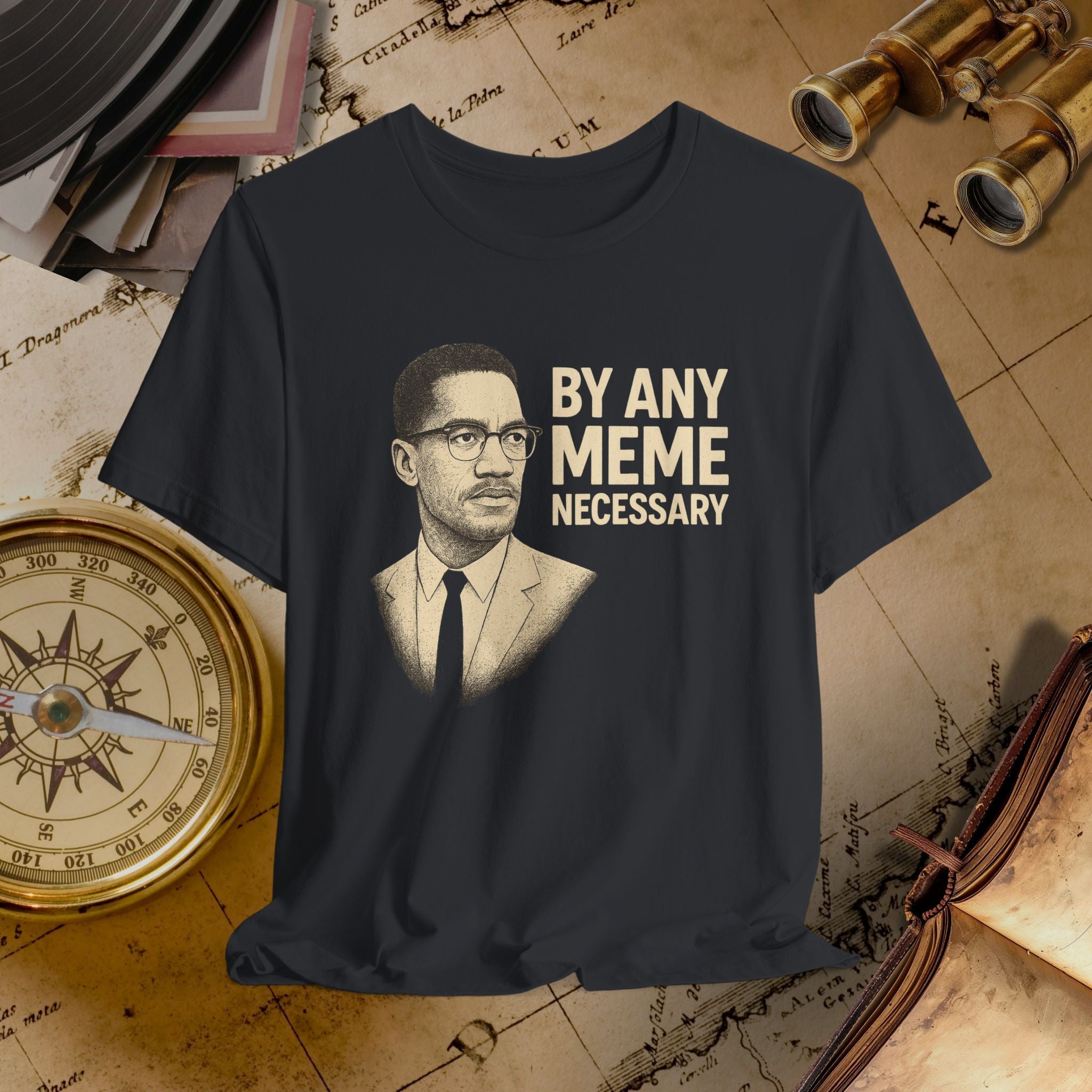 Black t-shirt with a graphic of a man's face and text 'By Any Meme Necessary' on a vintage map background.