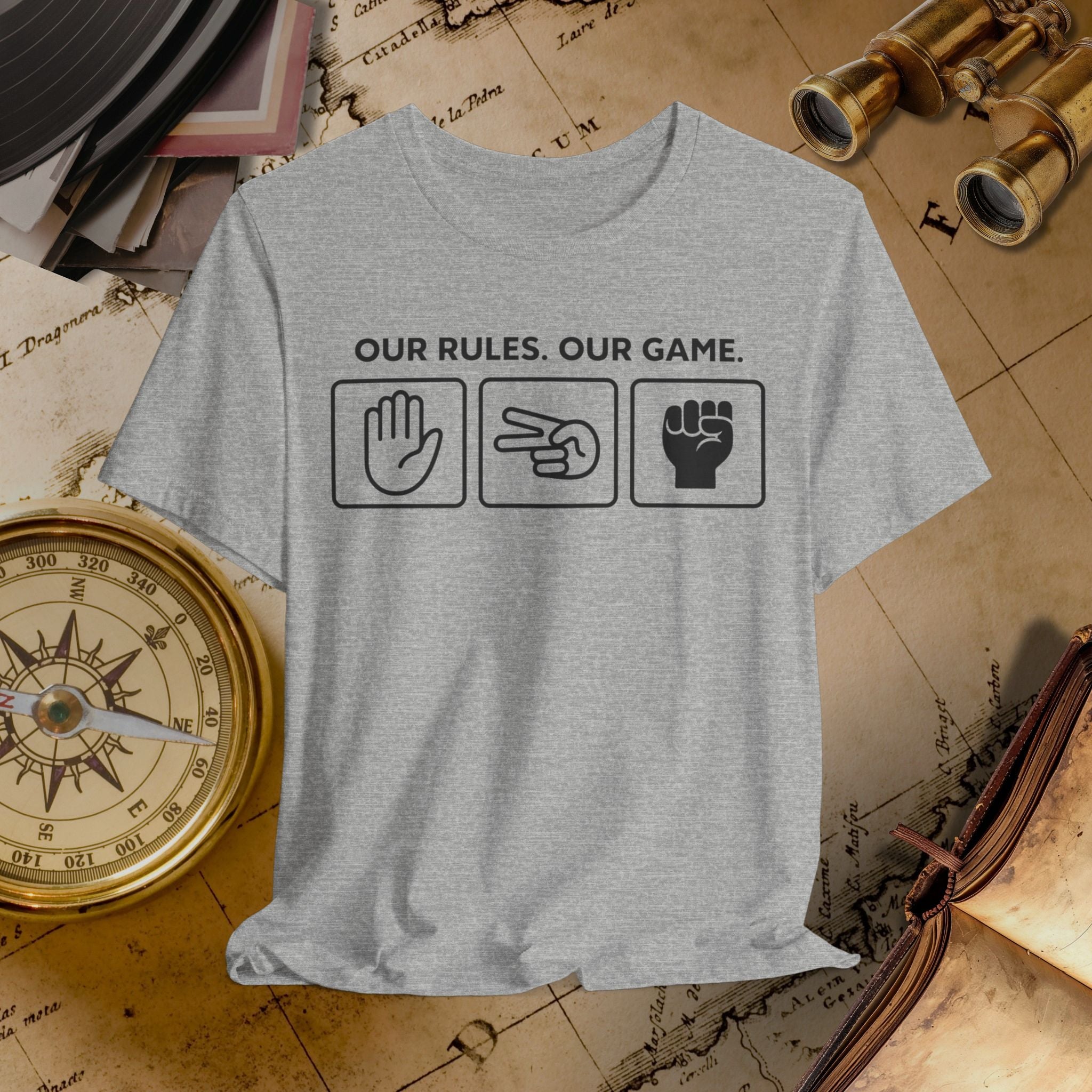 Gray t-shirt with 'Our Rules, Our Game' text and symbols on a vintage map background