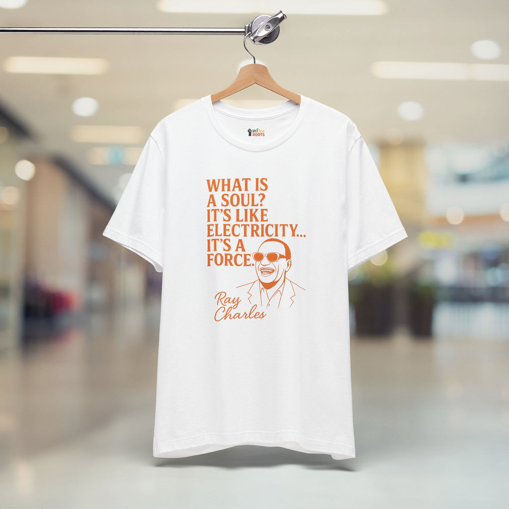White t-shirt with orange text and graphic of Ray Charles on a hanger in a store.