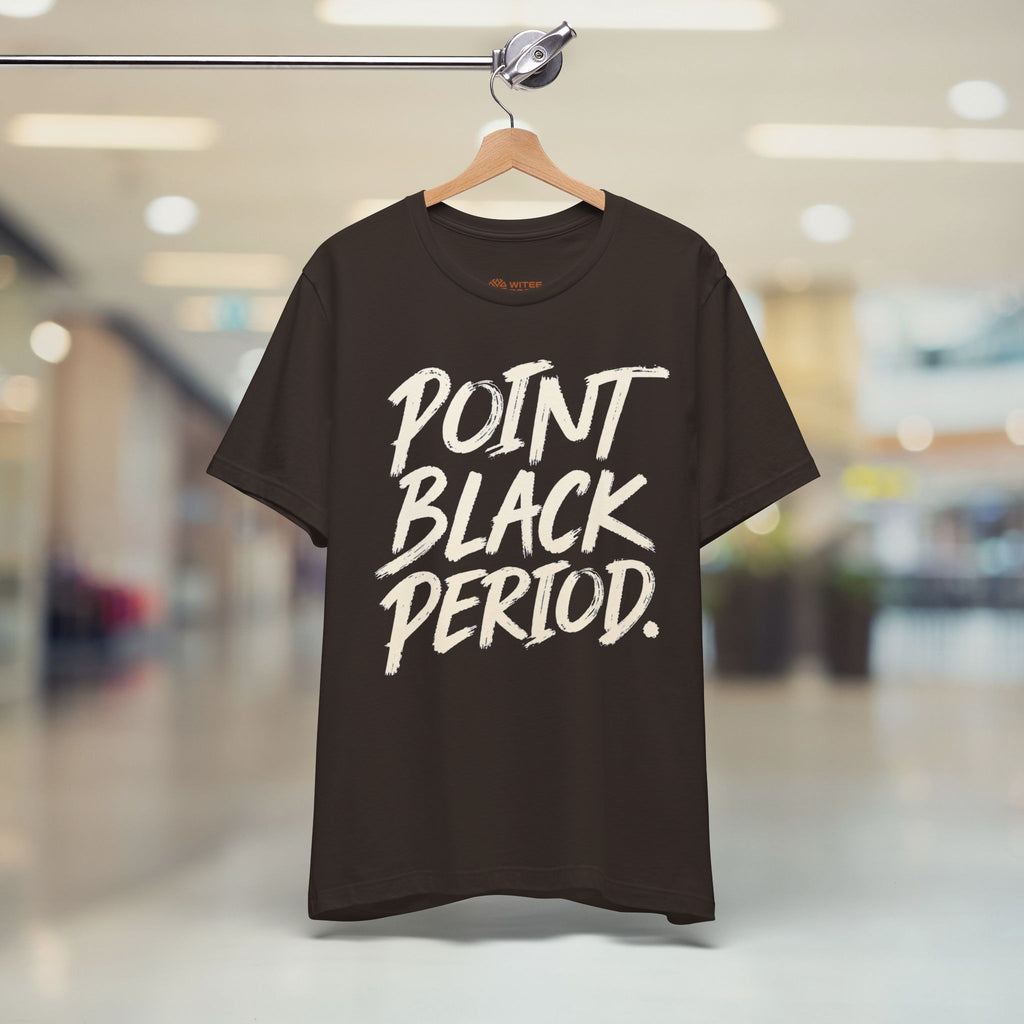 A dark brown short-sleeve t-shirt hanging on a wooden hanger from a clothing rack, featuring the text 'POINT BLACK PERIOD.' in a white brush-stroke font on the front.