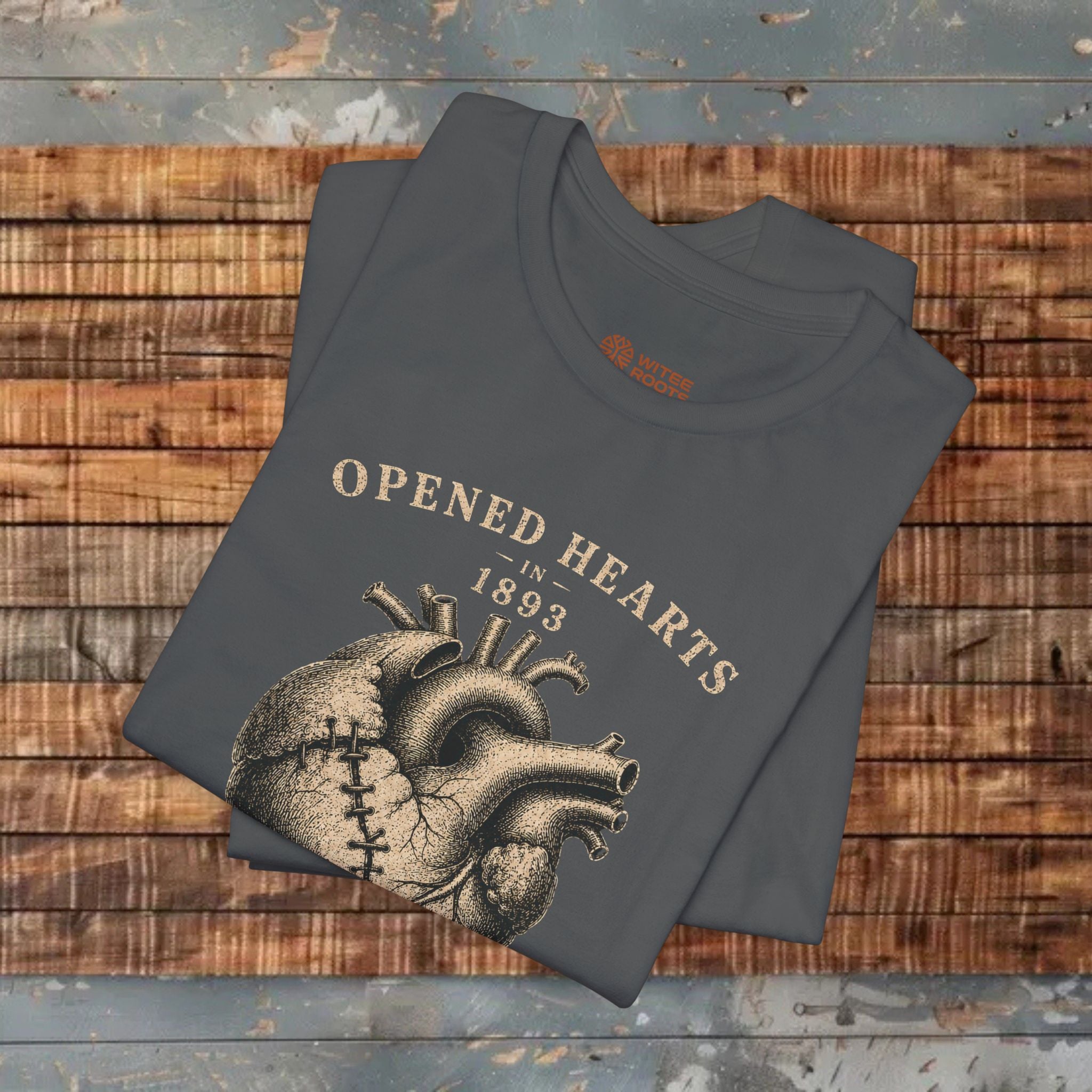 Folded t-shirt with heart design and text on a wooden surface