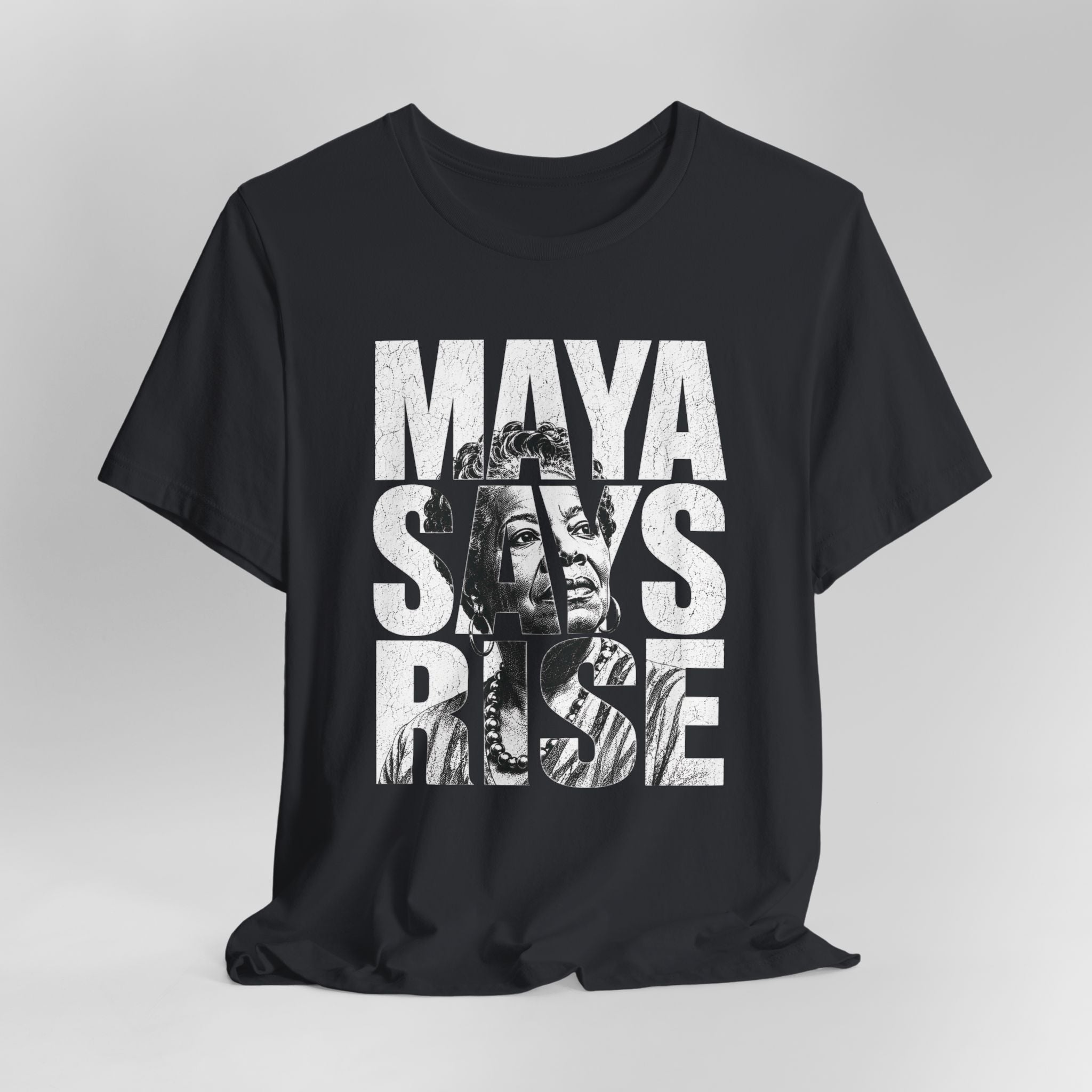 Black t-shirt with 'Maya Says Rise' text and graphic on a gray background