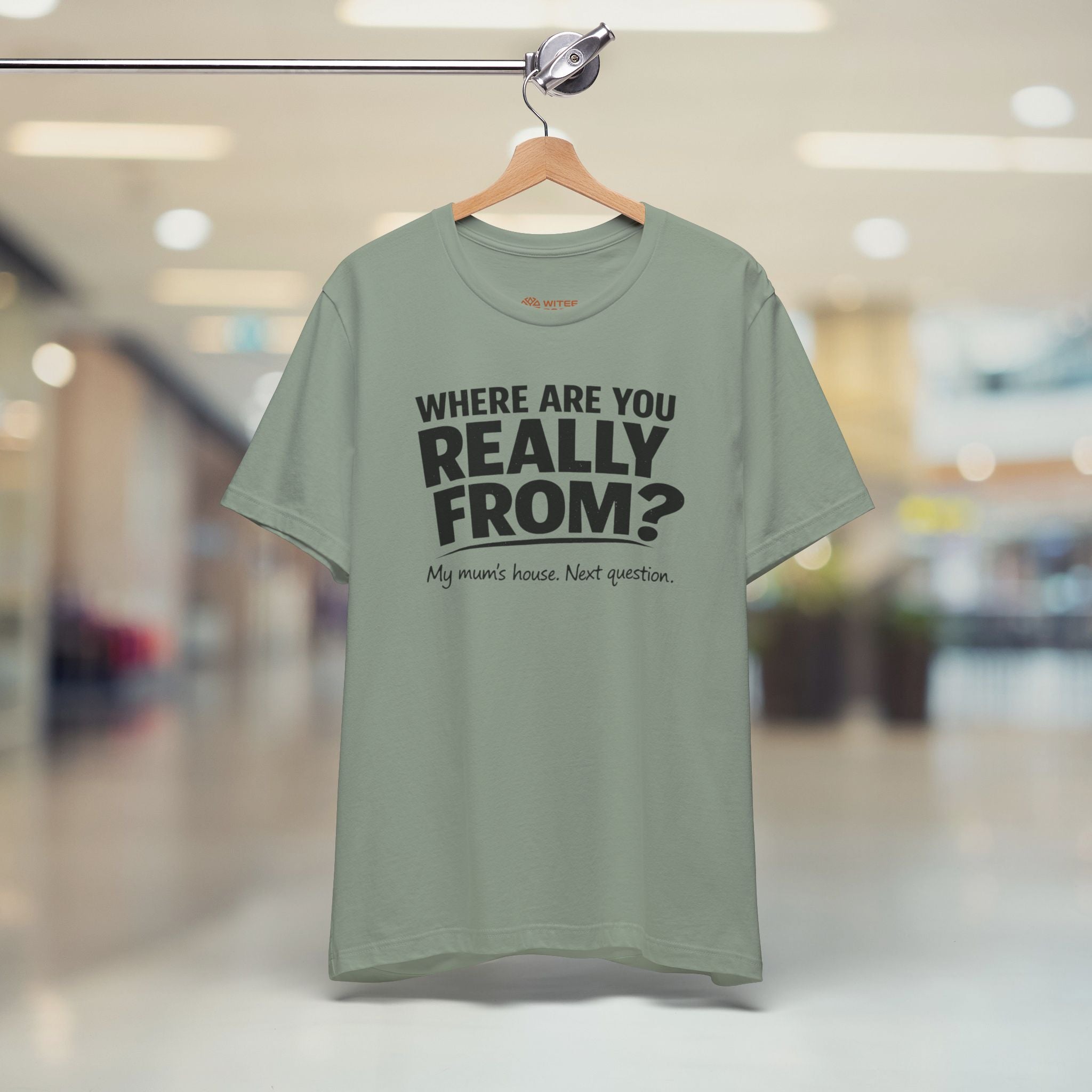 Green t-shirt with text on a hanger in a store setting
