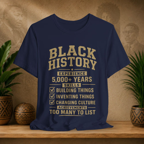 Navy blue t-shirt with 'Black History' text on a wooden surface with plants and decorative items.