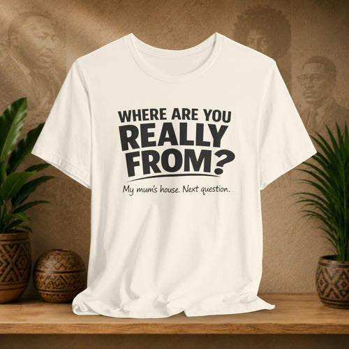Beige t-shirt with humorous text on a wooden surface with plants and a blurred background