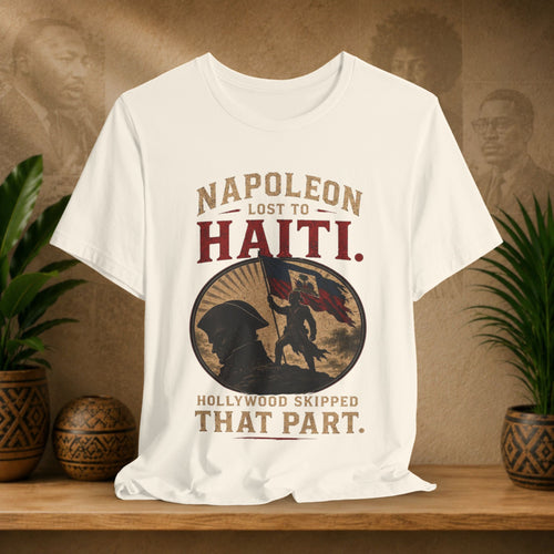 Beige t-shirt with graphic design and text on a wooden surface with plants and a brown background