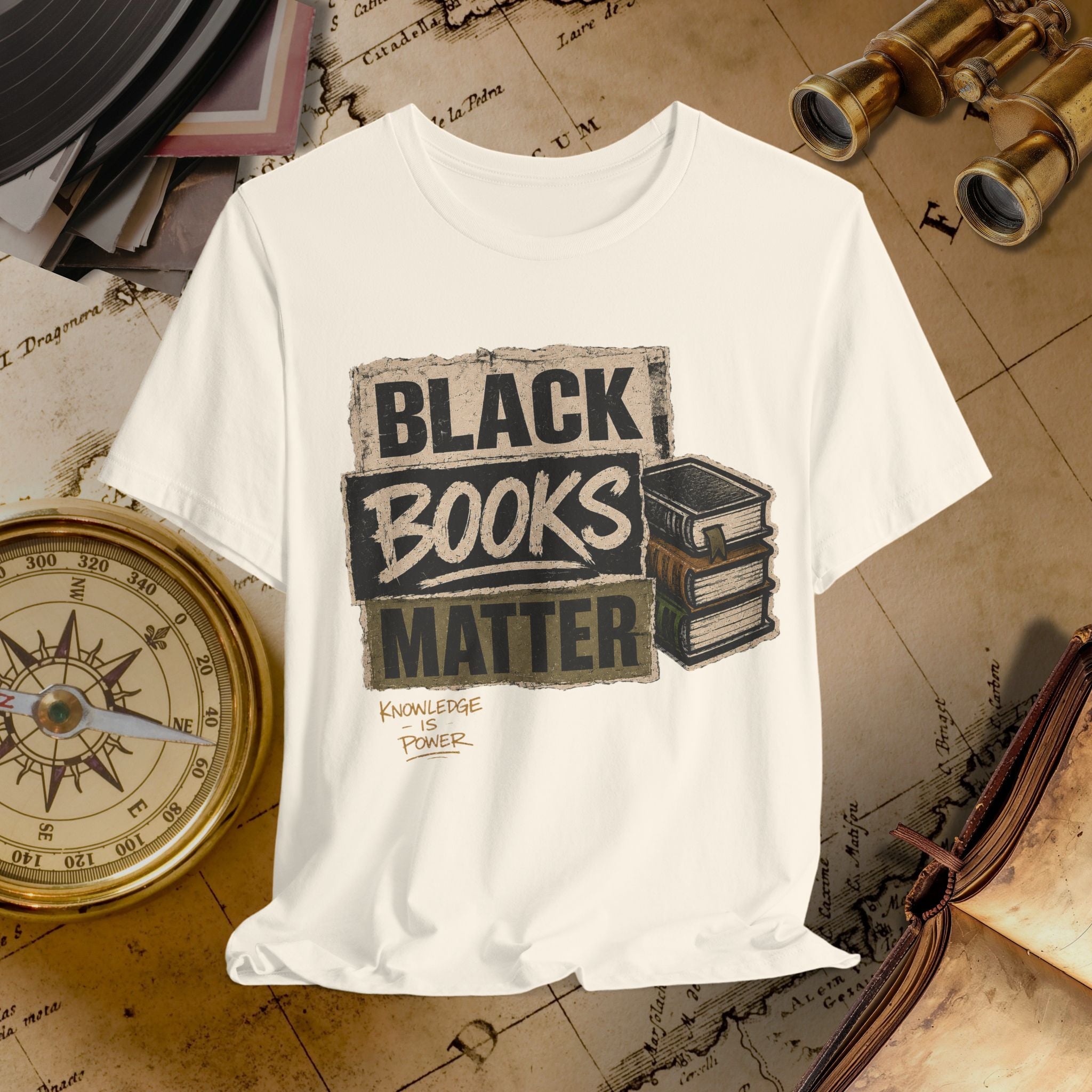 Beige t-shirt with 'Black Books Matter' graphic on a vintage background with books and binoculars.
