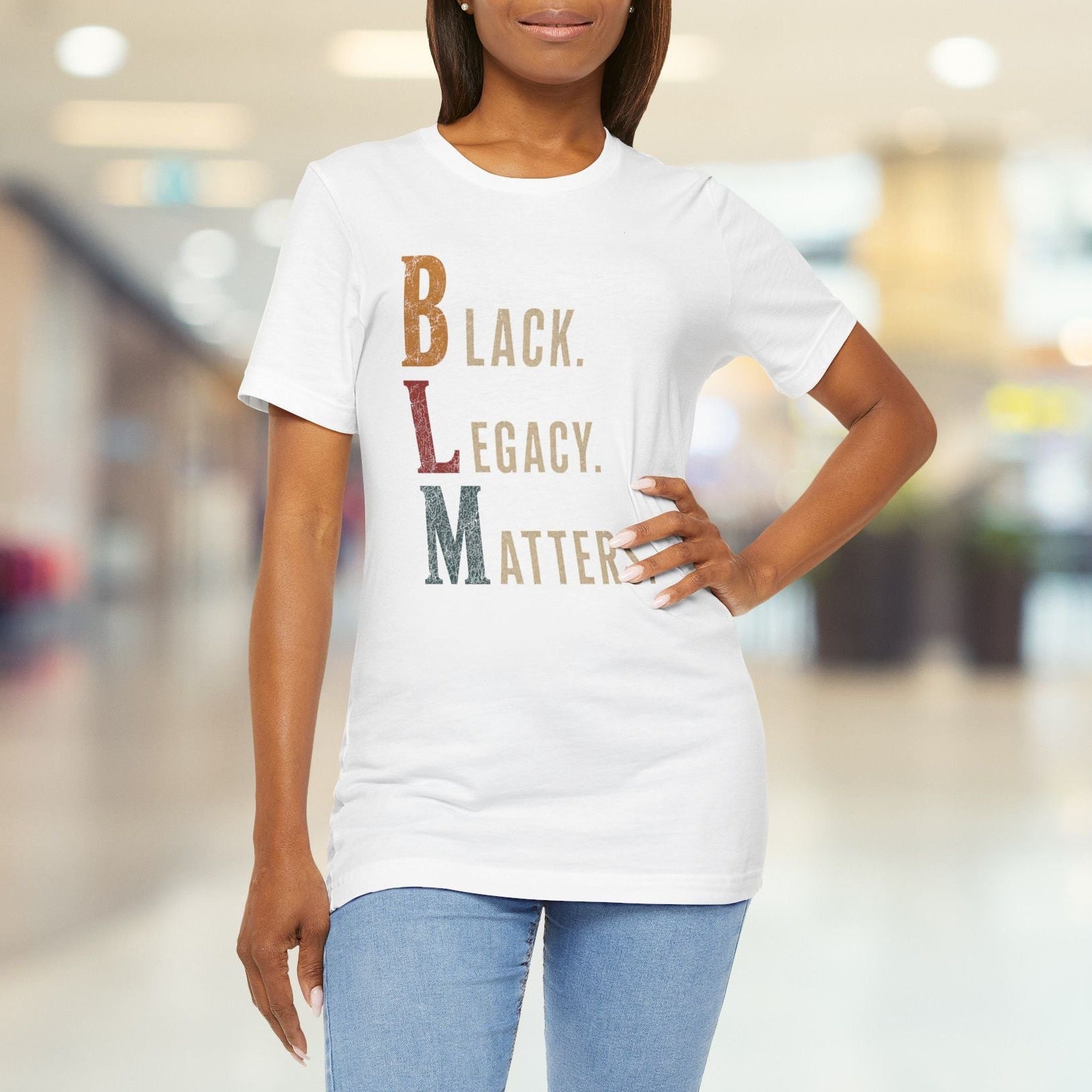A woman wearing a white graphic t-shirt with the text 'Black. Legacy.