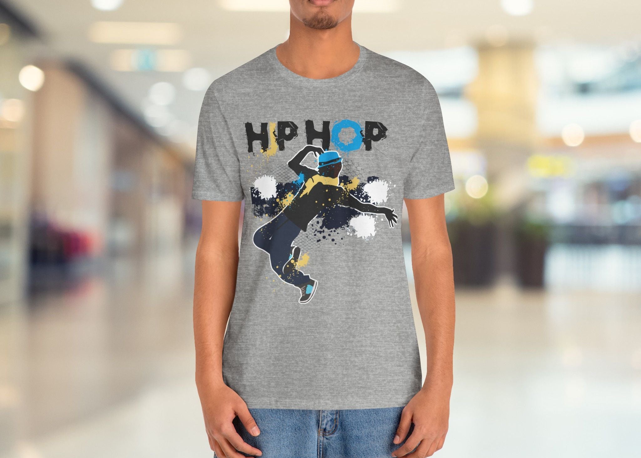 Person wearing a gray t-shirt with a graphic design and text in a mall setting