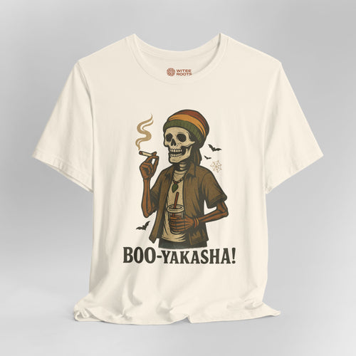An off-white short-sleeve t-shirt with a graphic of a skeleton wearing a Rasta hat and holding a cigar and a drink, with the text 'BOO-YAKASHA!' printed below. The shirt is shown on a neutral gray background.