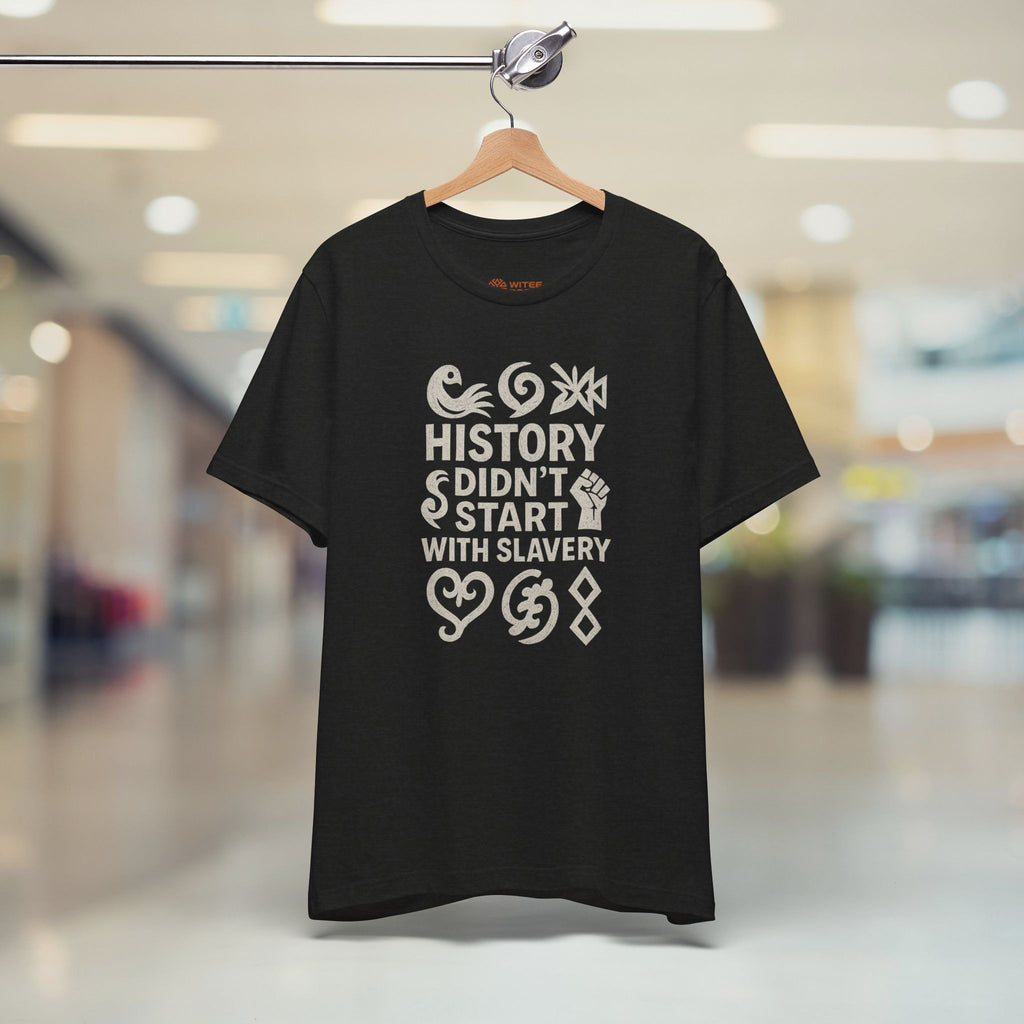 Black t-shirt with white text and graphics on a hanger in a store setting