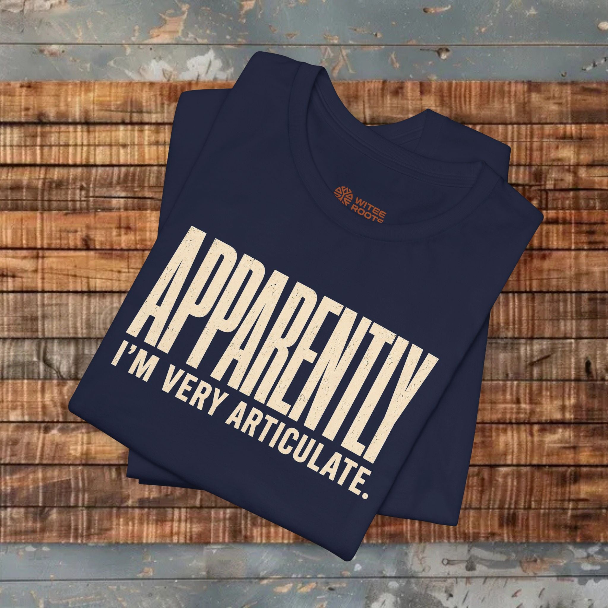 Folded navy blue t-shirt with white text on a wooden surface