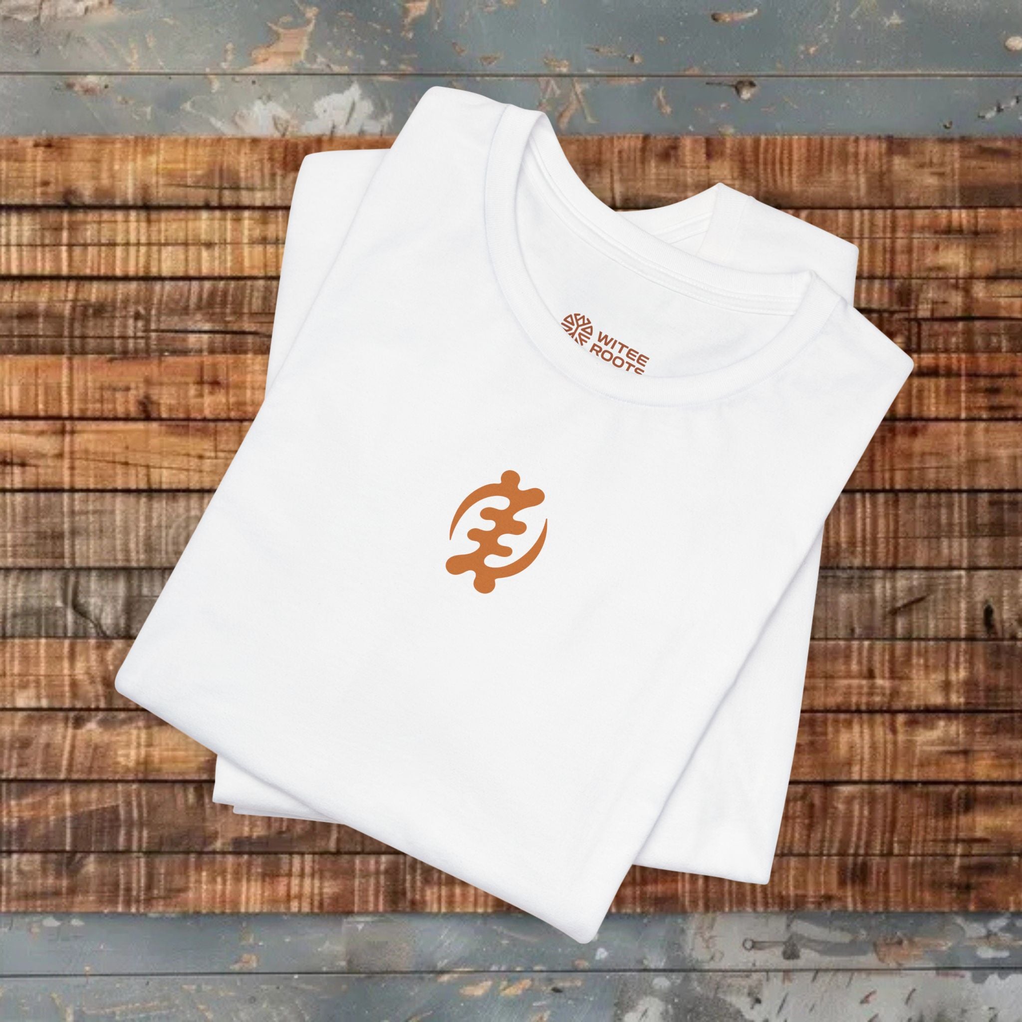 White t-shirt with orange logo on a wooden surface