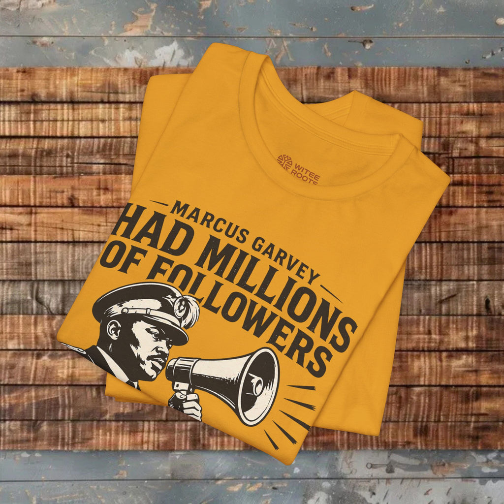 Yellow t-shirt with graphic design and text on a wooden surface