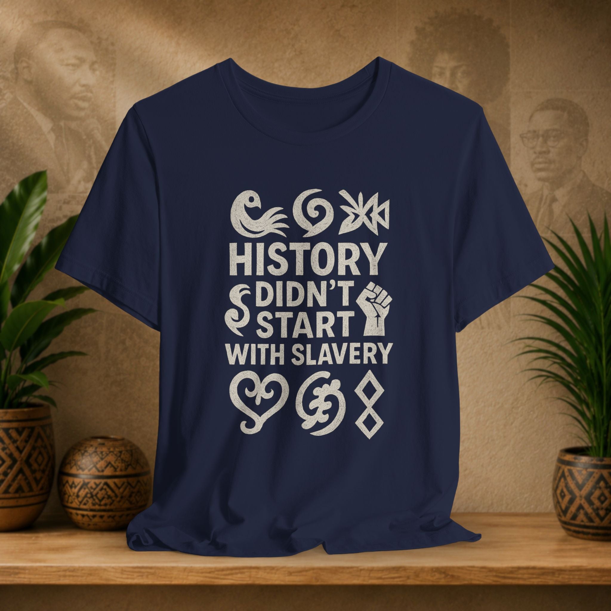 Navy blue t-shirt with white text on a wooden surface with decorative items in the background
