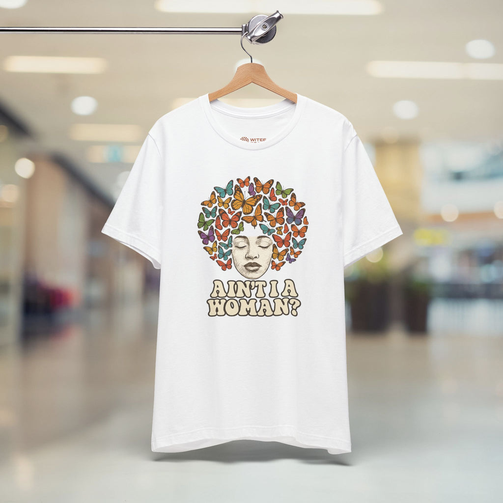 White t-shirt with a colorful butterfly design and text on a hanger in a store.