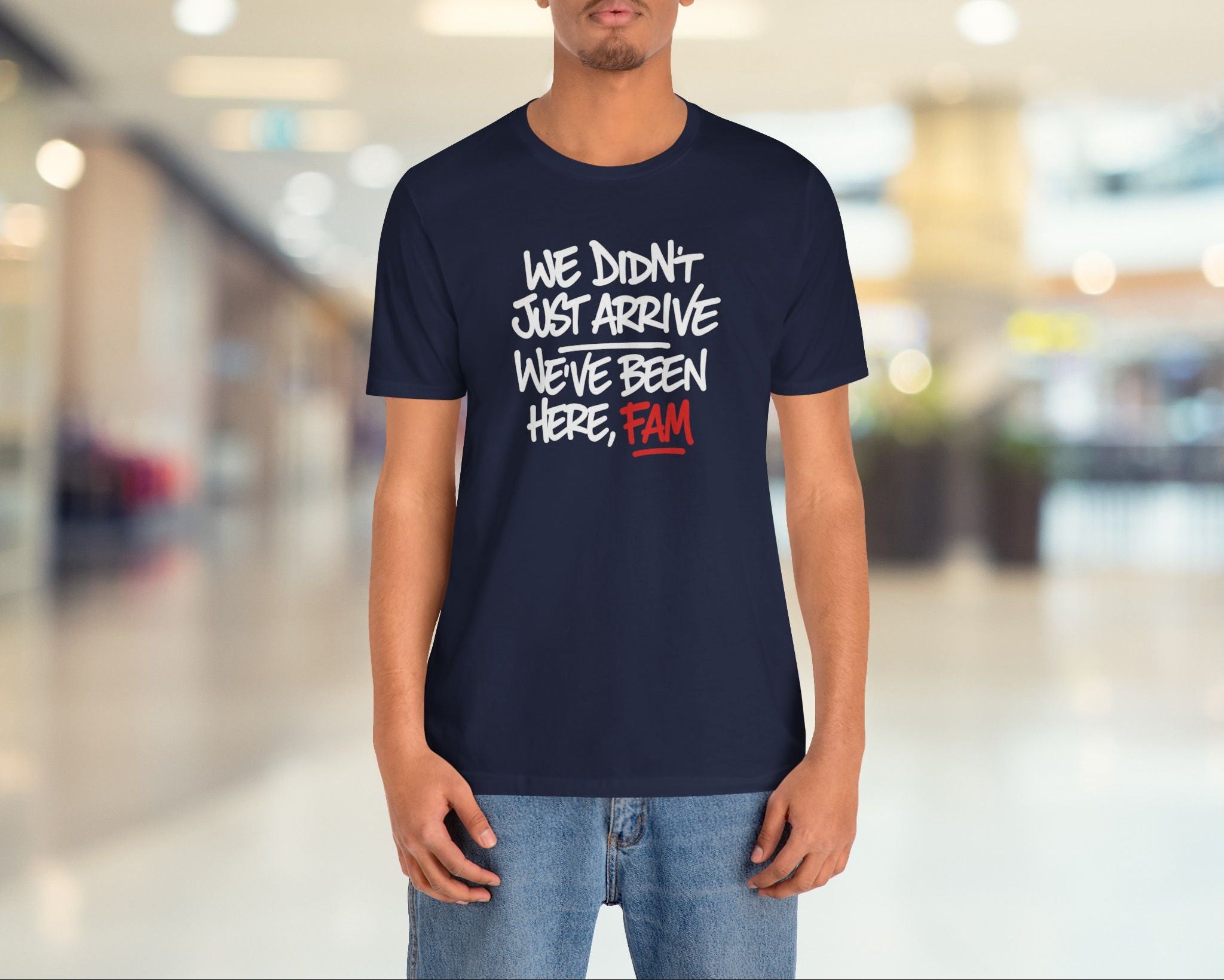 Person wearing a navy blue t-shirt with text in a mall setting