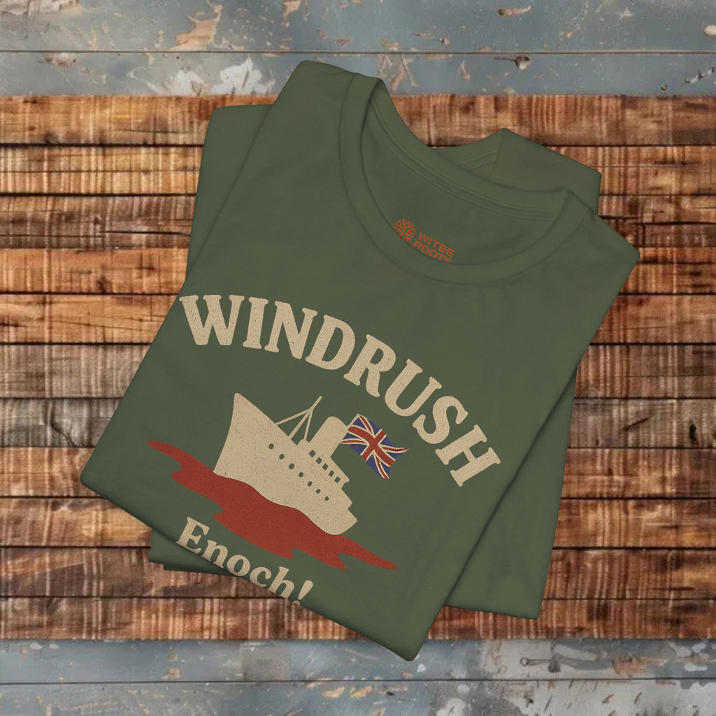 Folded green t-shirt with 'Windrush Enoch!' design on a wooden surface