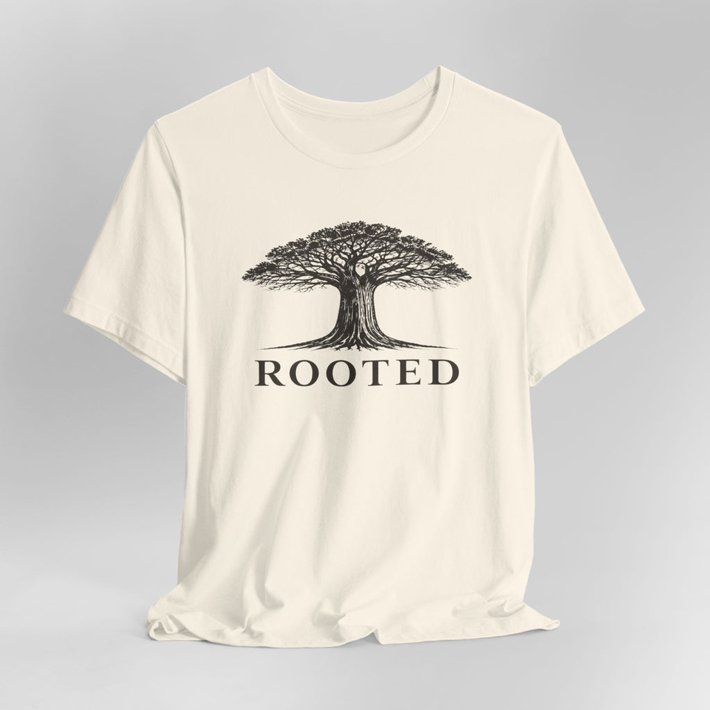 Beige t-shirt with a tree graphic and 'ROOTED' text on a gray background