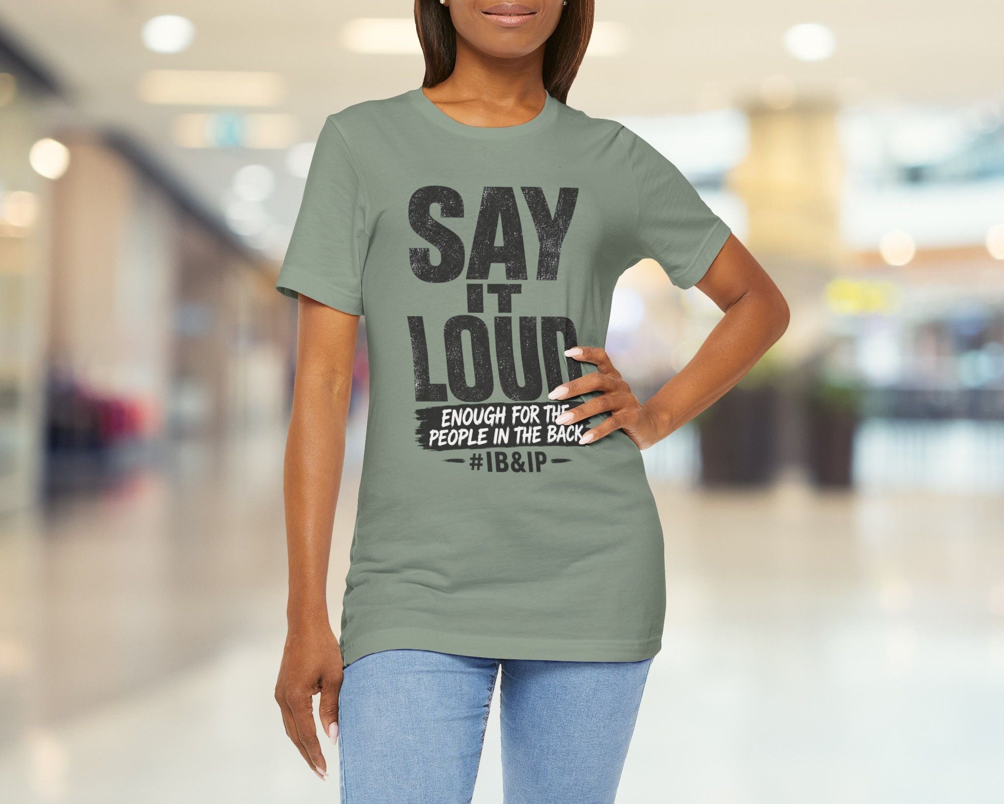 Woman wearing a green t-shirt with a message in a blurred indoor setting