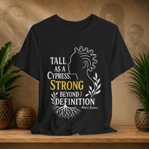 Black t-shirt with motivational quote on a wooden surface with plants and decorative items.