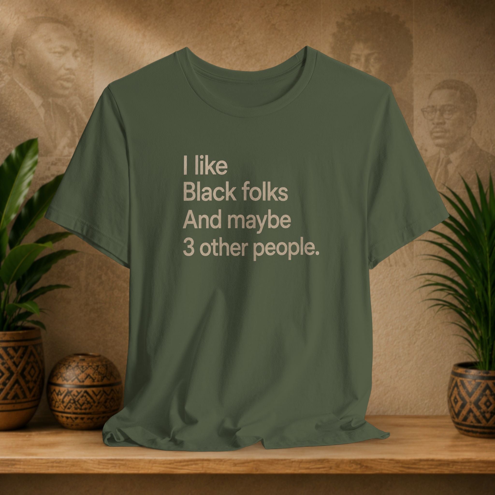 A military green graphic t-shirt with the text 'I like Black folks And maybe 3 other people.' printed in a light beige sans-serif font.