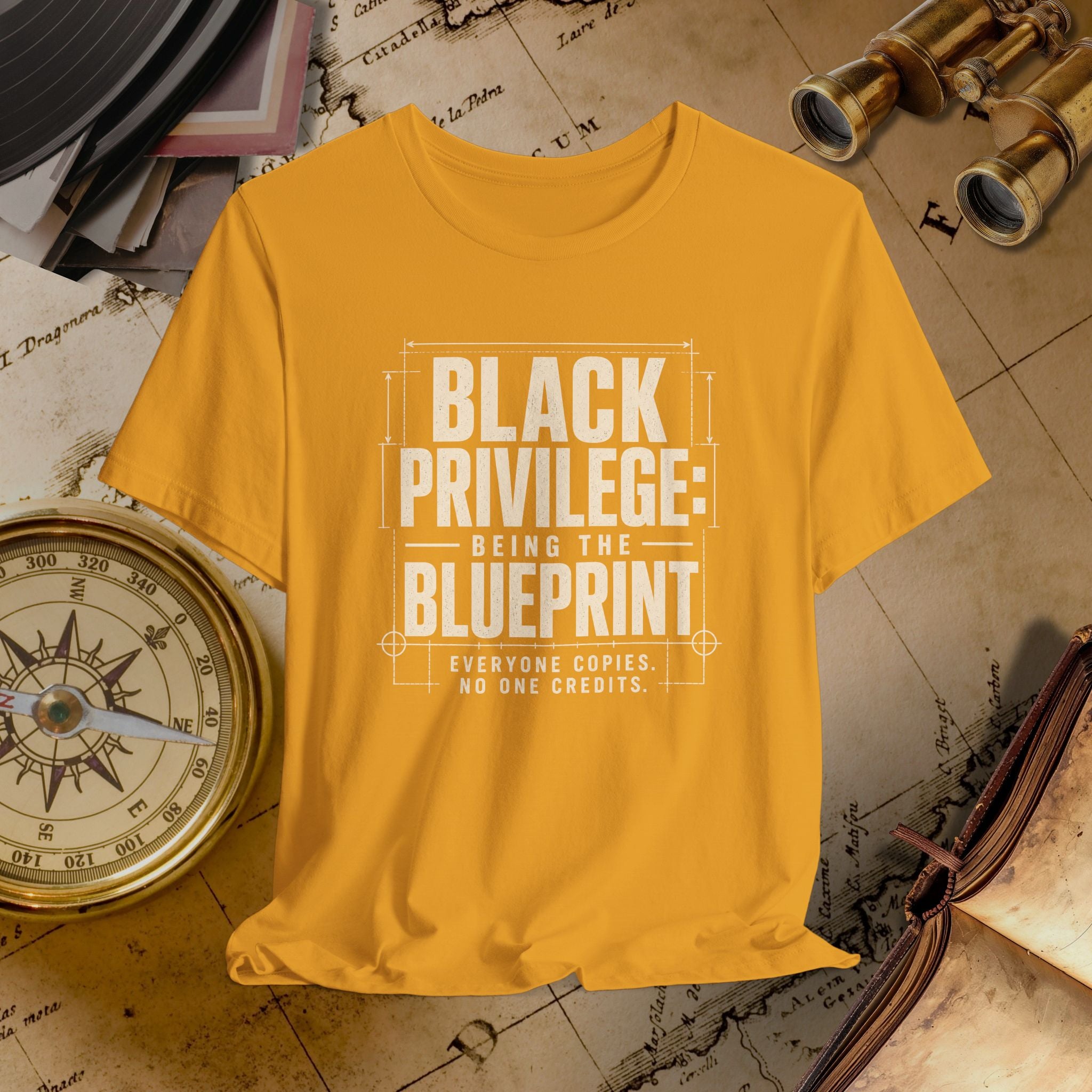 Mustard t-shirt with 'Black Privilege: Being the Blueprint' text on a vintage map background