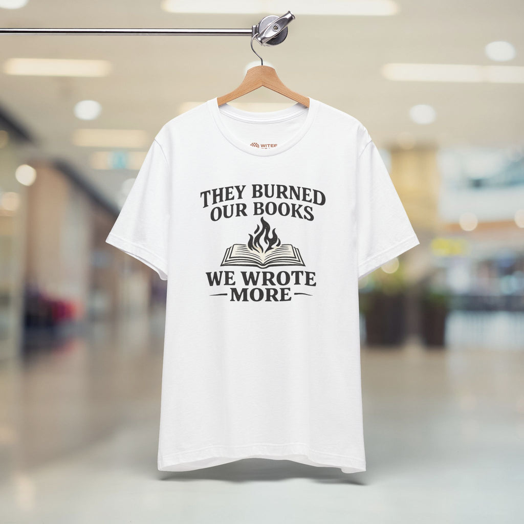 White t-shirt with black text and graphic on a hanger in a store.