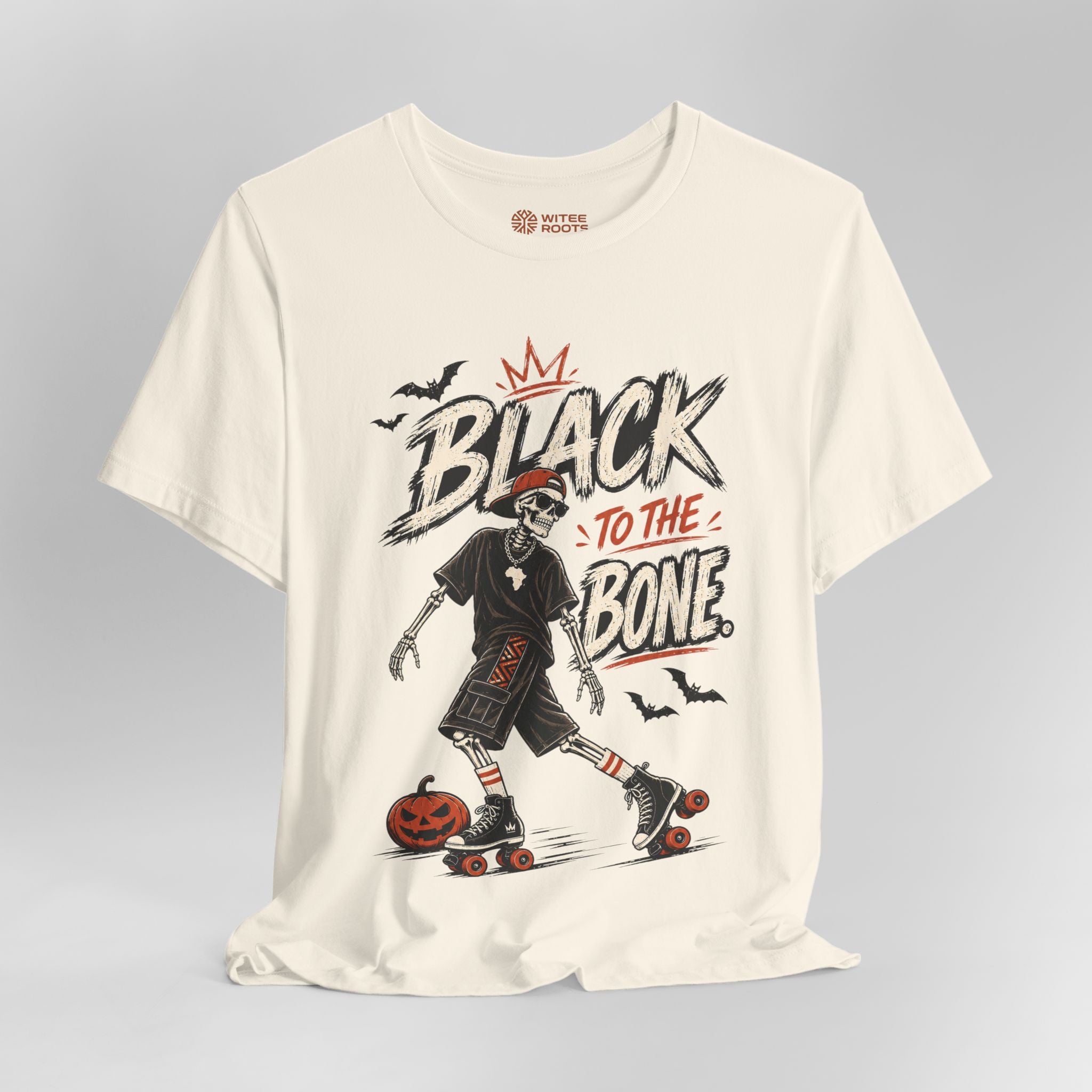 An off-white short-sleeve t-shirt with a graphic print of a skeleton roller skateer next to a jack-o'-lantern, featuring the text 'BLACK TO THE BONE' and 'BUTTERFLY BOOT' on the inner neck label.