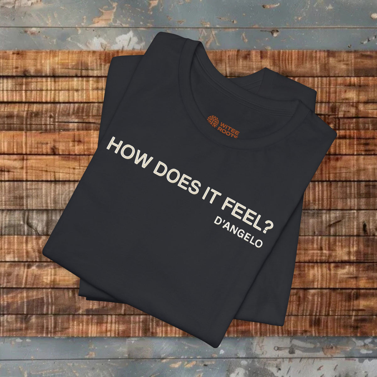 Folded black t-shirt with text on a wooden surface