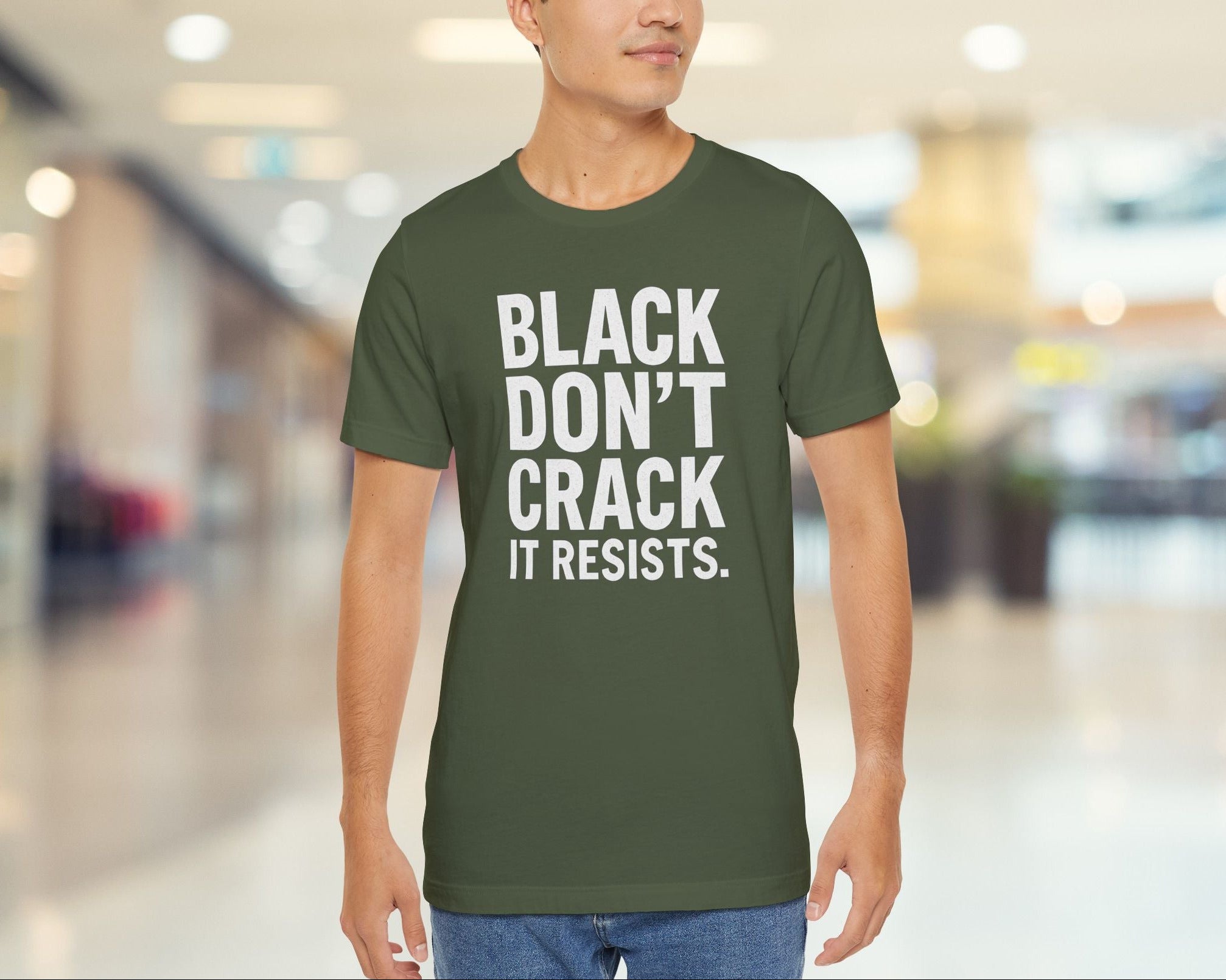 Person wearing a green t-shirt with text in a blurred indoor setting