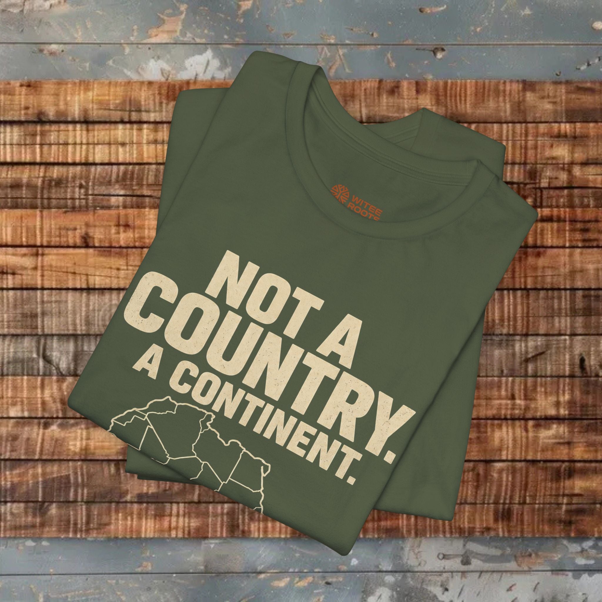 Green t-shirt with text 'Not a country. A continent.' on a wooden surface