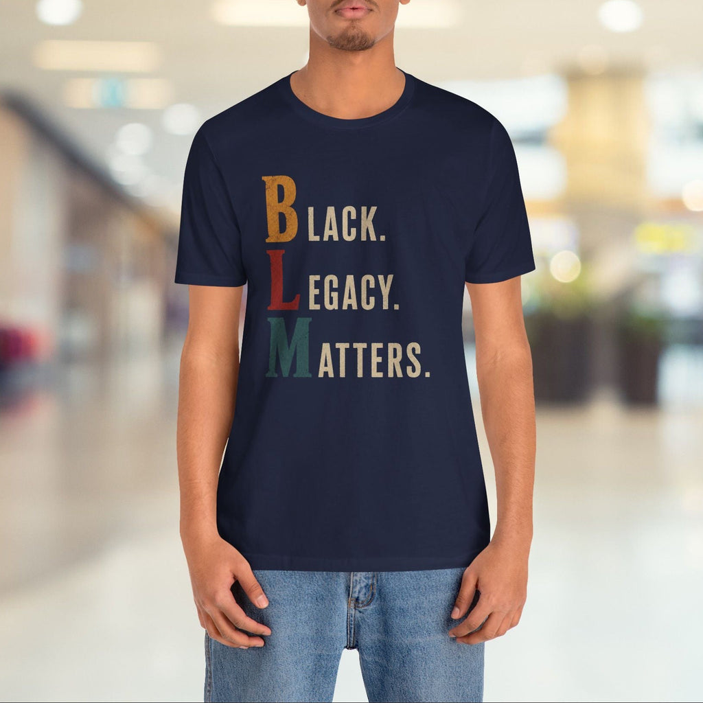A man wearing a navy blue graphic t-shirt with the text 'Black. Legacy.