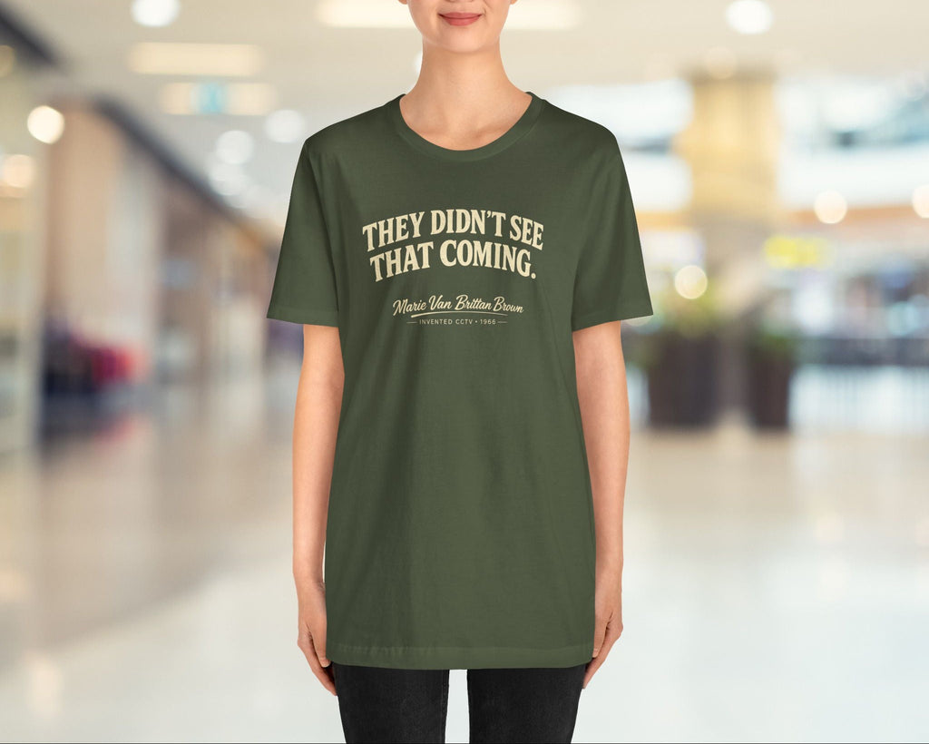 Person wearing a green t-shirt with text in a blurred indoor setting