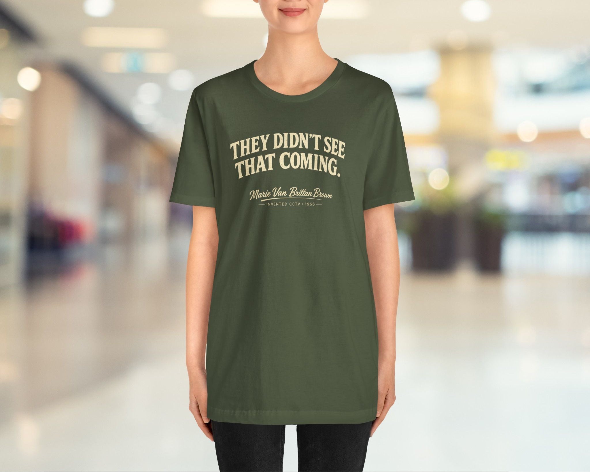 Person wearing a green t-shirt with text in a blurred indoor setting