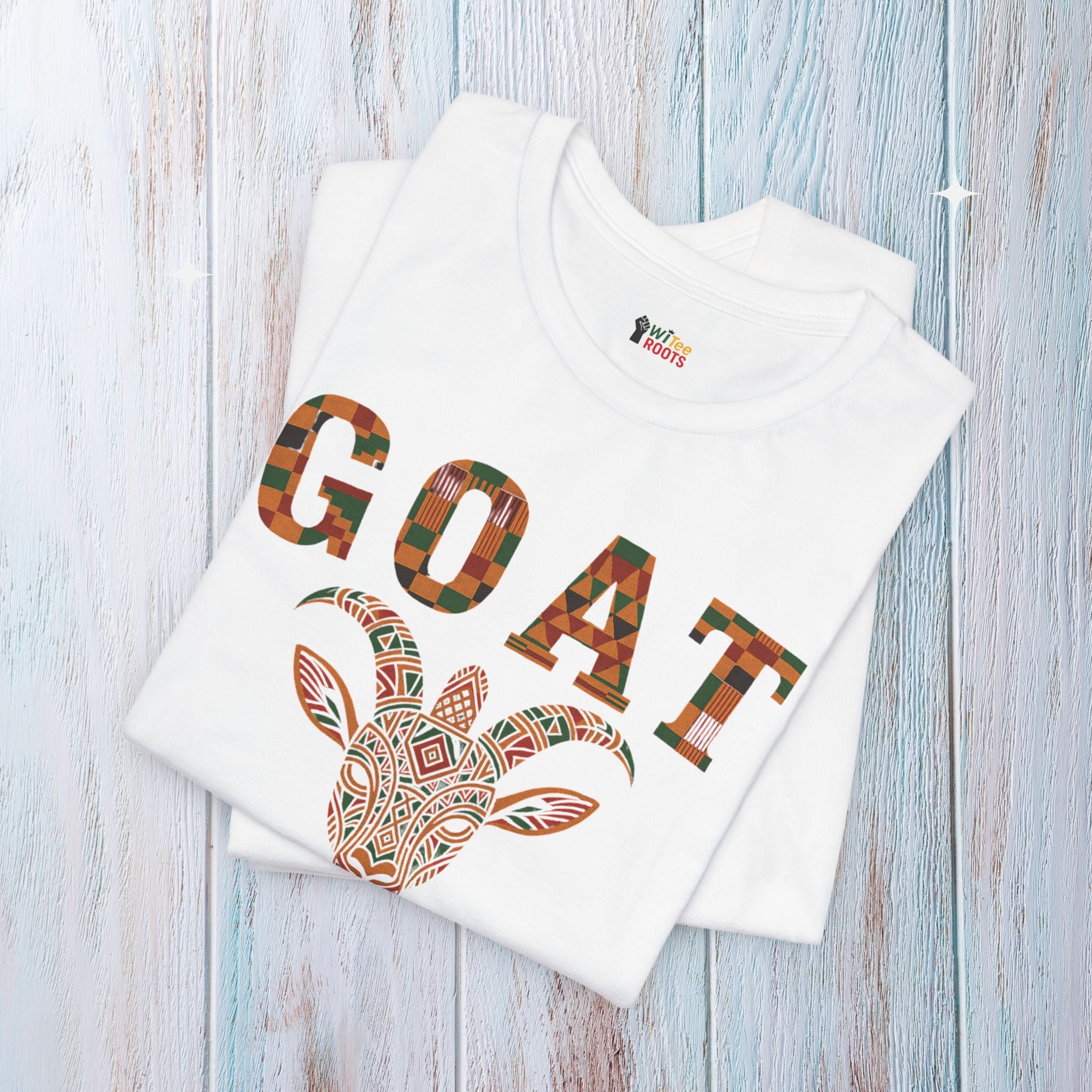 White t-shirt with 'GOAT' design on a wooden surface
