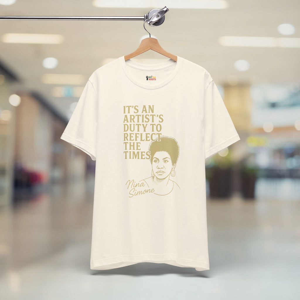 Beige t-shirt with text and a graphic of Nina Simone on a hanger in a store.