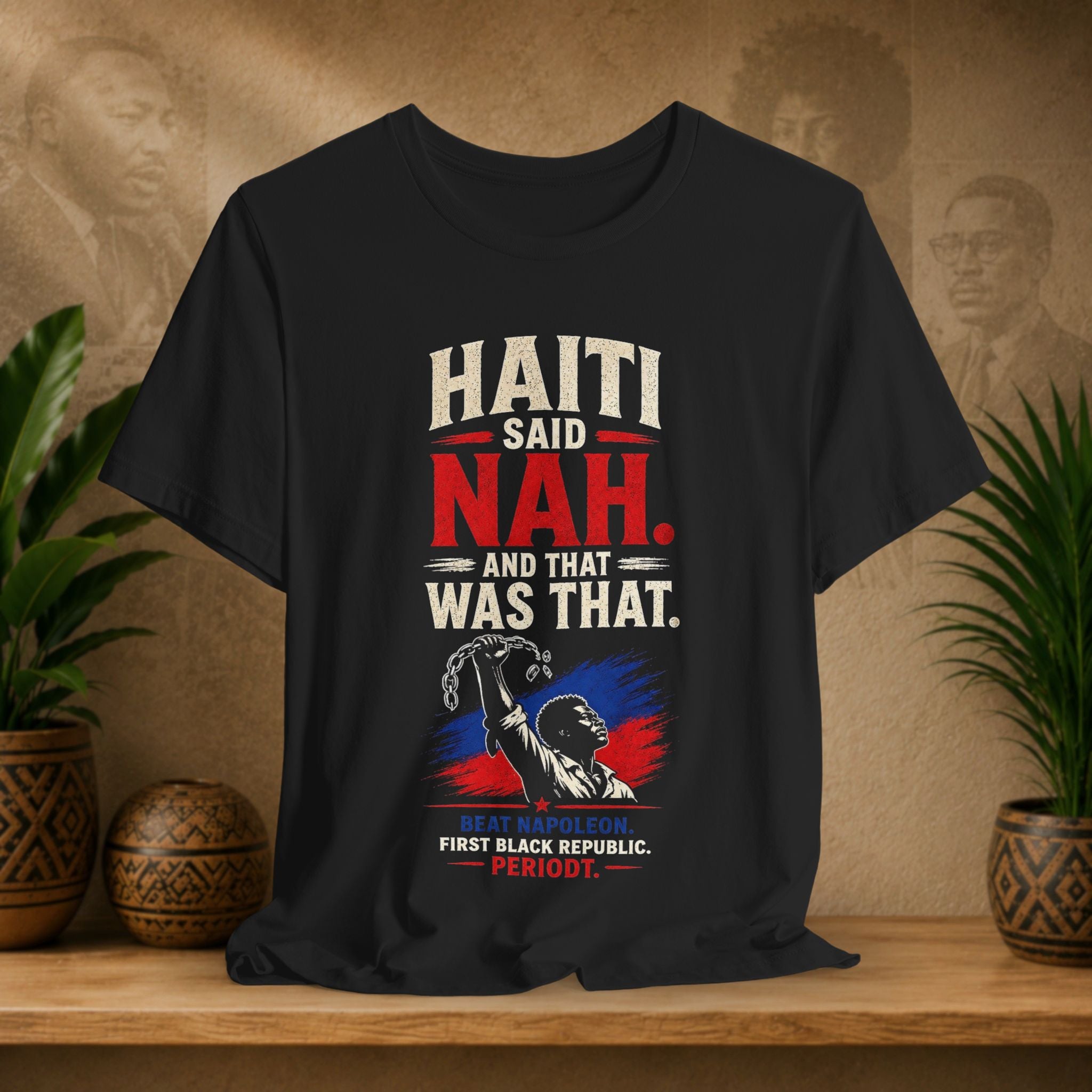 Black t-shirt with political graphic and text on a wooden surface with plants and decorative items.