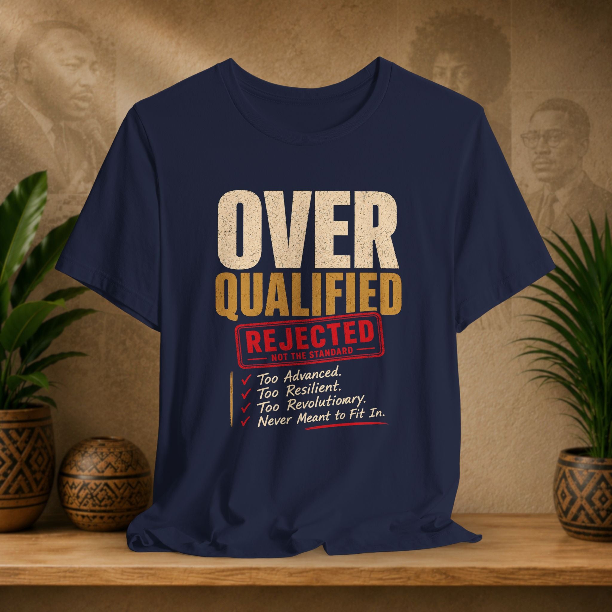 Navy blue t-shirt with humorous text design on a wooden surface with plants and decorative items.