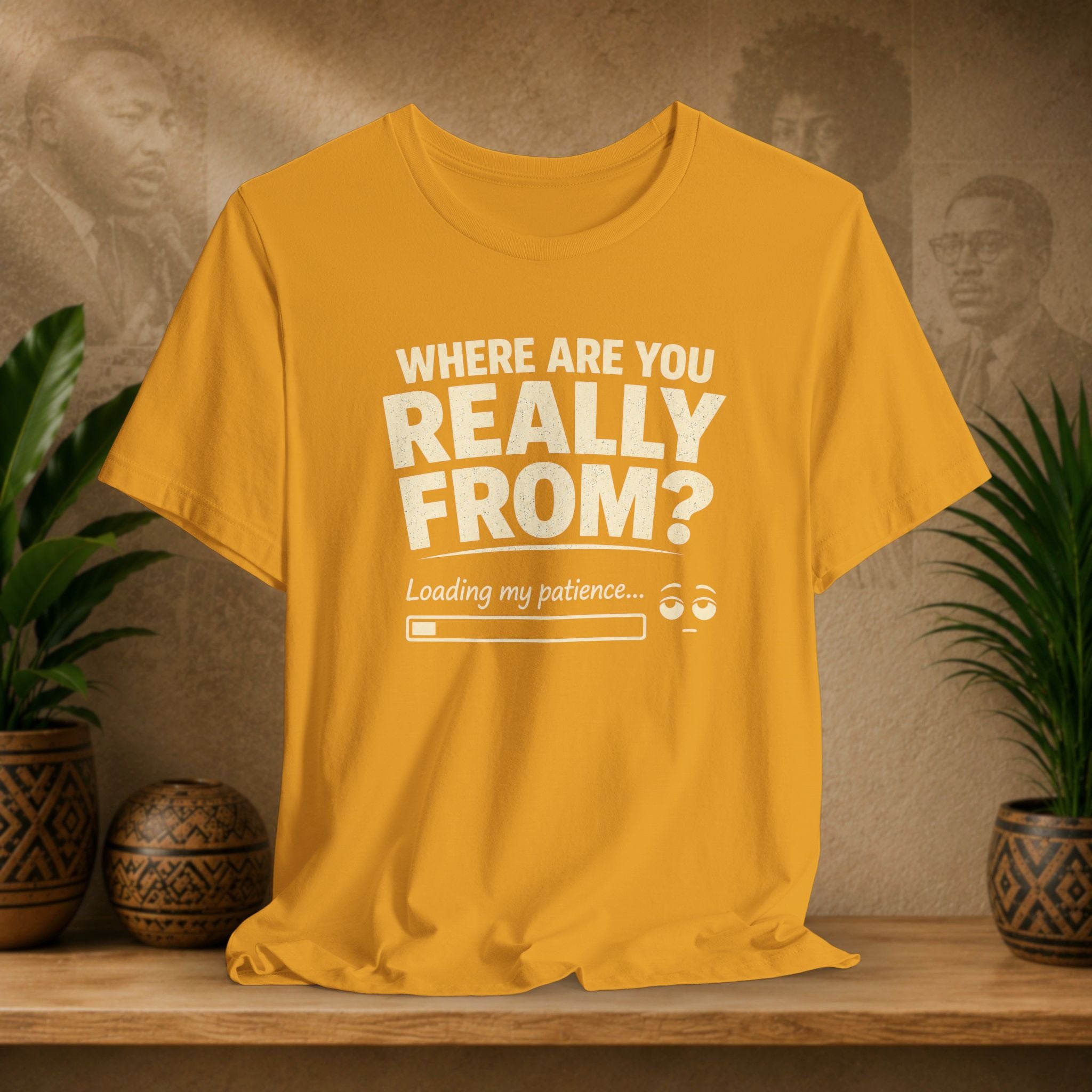 Mustard t-shirt with humorous text design on a wooden surface with plants and a textured wall background