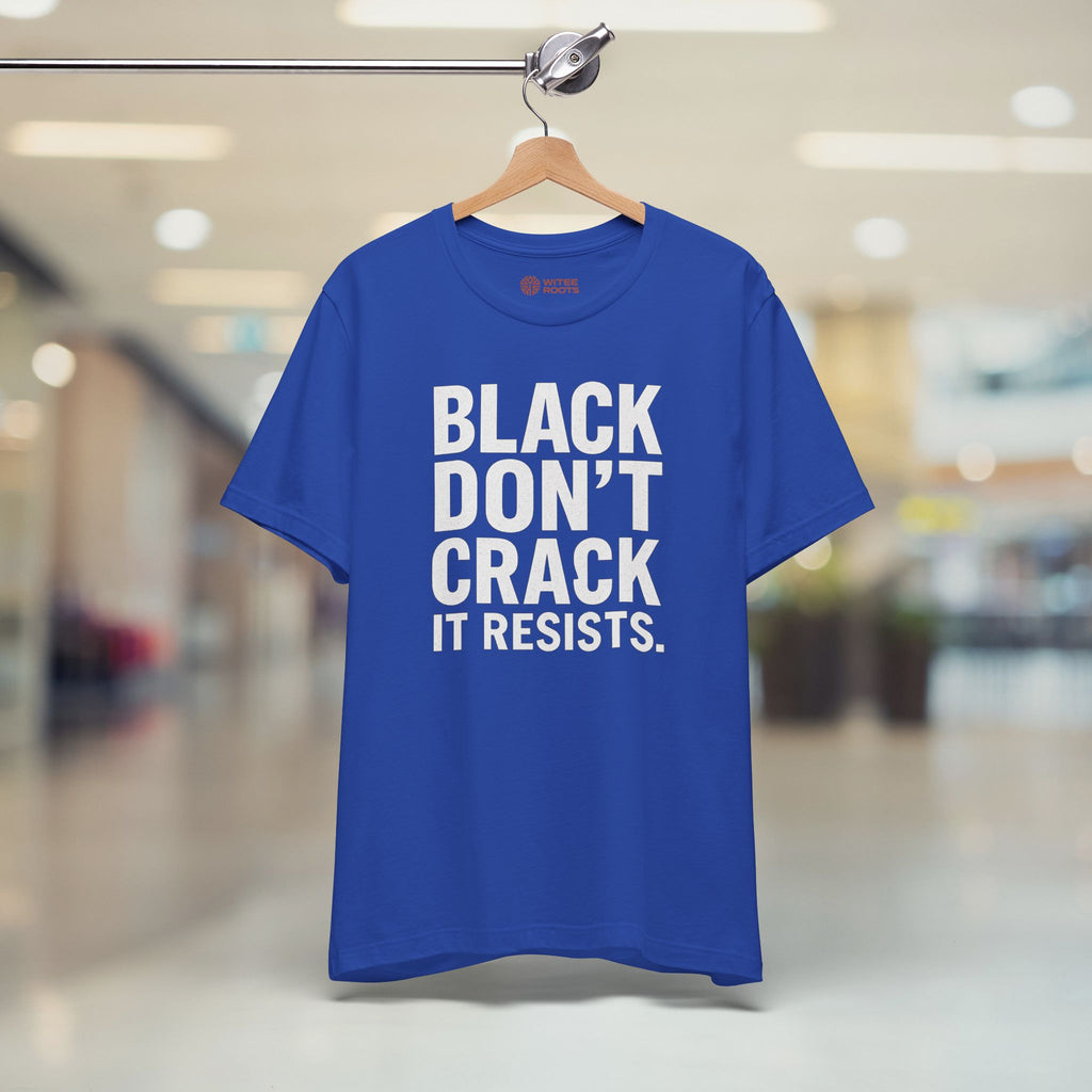 Blue t-shirt with white text 'BLACK DON'T CRACK IT RESISTS.' on a hanger in a store.