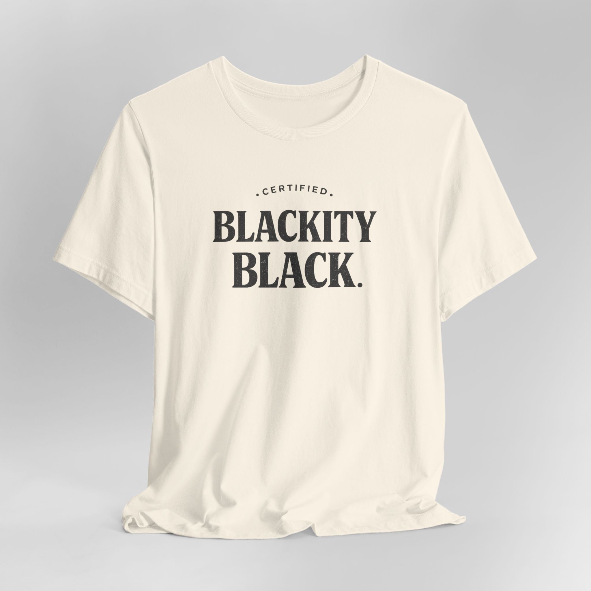 Beige t-shirt with 'CERTIFIED BLACKITY BLACK' text on a gray background