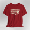 Red t-shirt with 'Reparations in Progress' graphic on a gray background