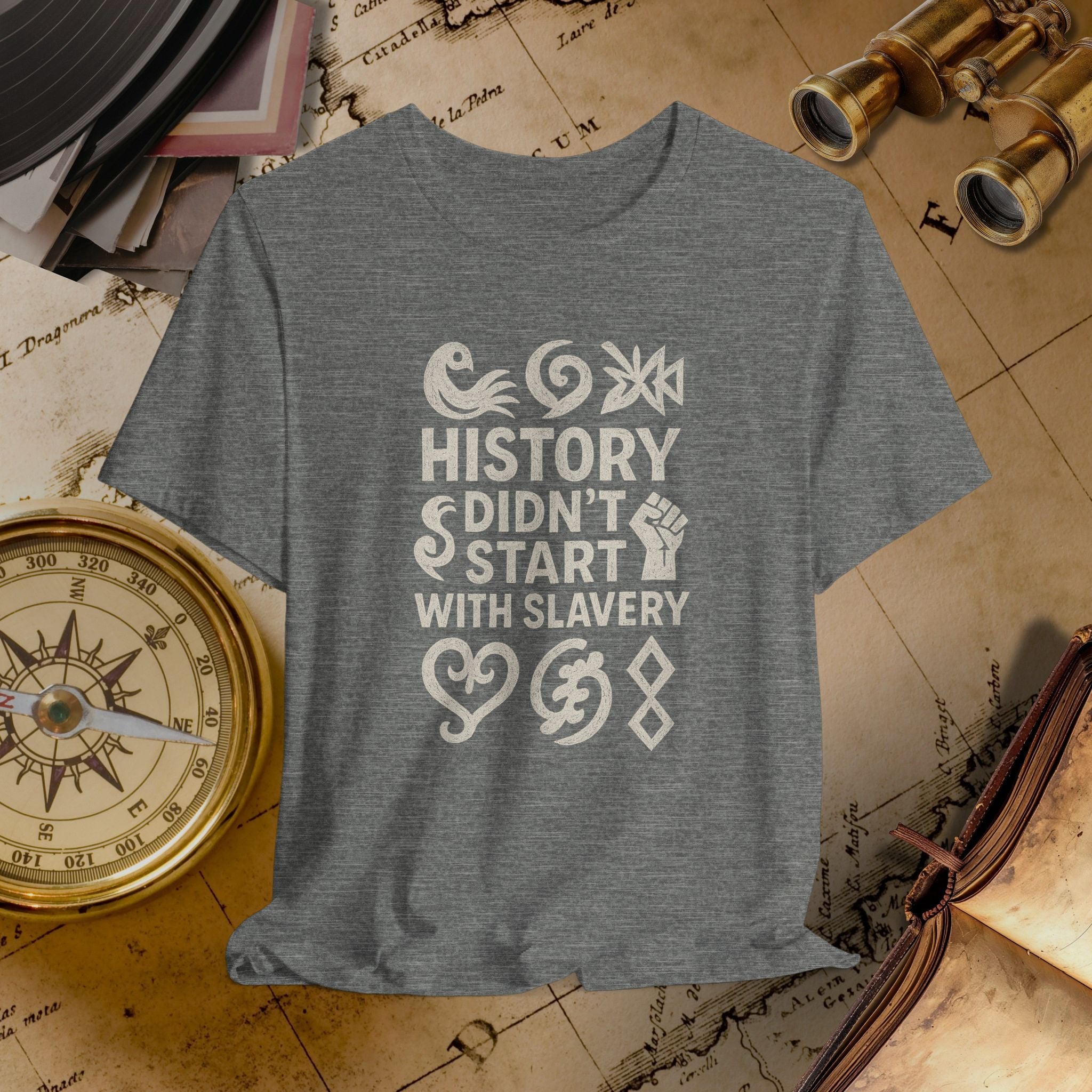 Gray t-shirt with 'History didn't start with slavery' text on a vintage map background