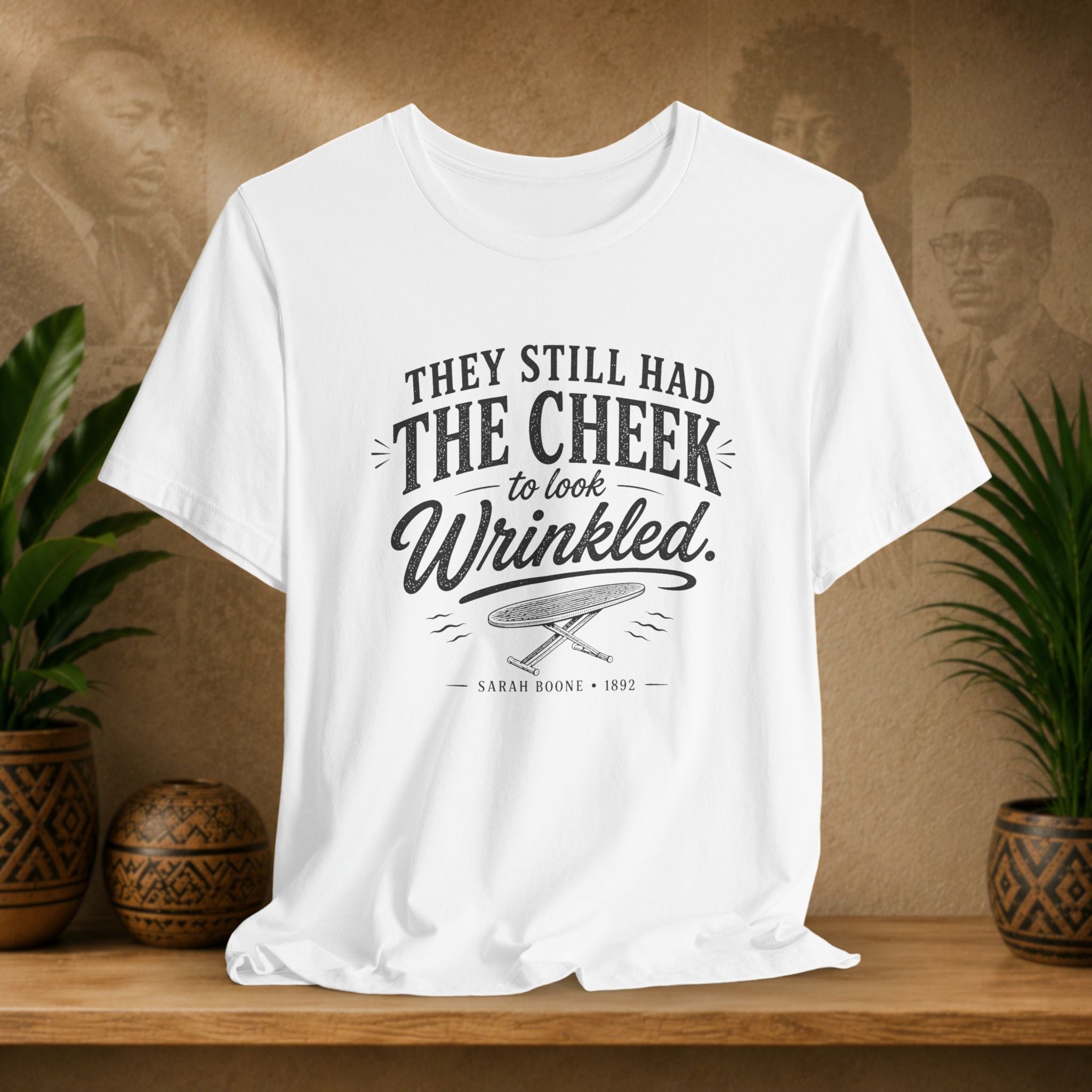 White t-shirt with text on a wooden surface with plants and a vintage-style background