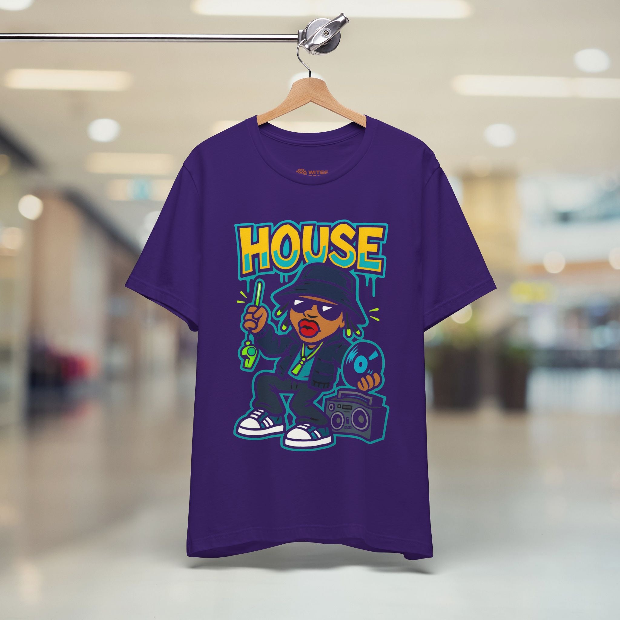 Purple t-shirt with cartoon character and 'HOUSE' text on a hanger in a store setting