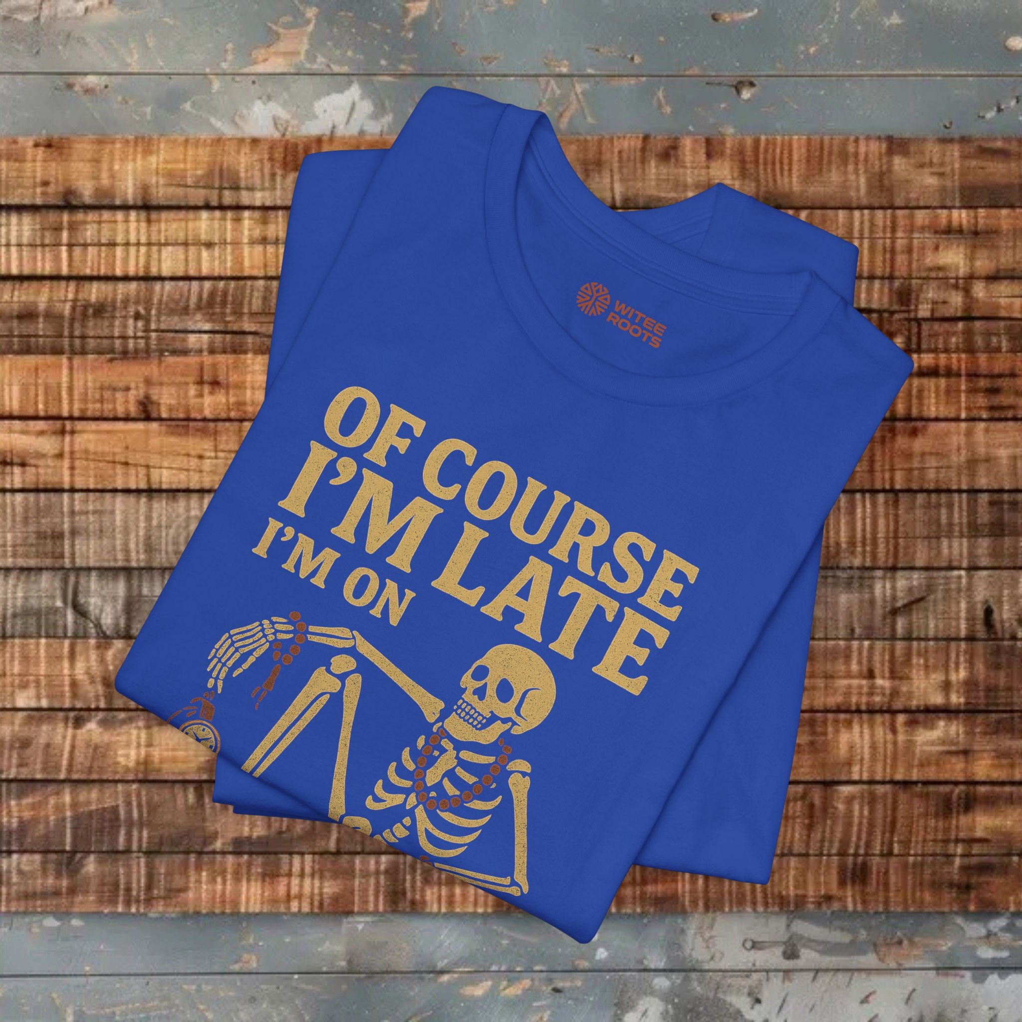 Blue t-shirt with yellow text and skeleton graphic on a wooden surface