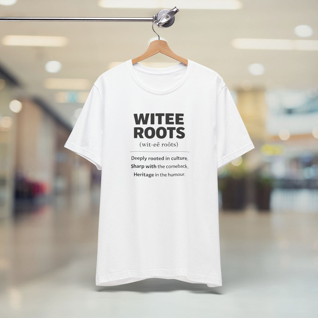 White t-shirt with black text on a hanger in a blurred indoor setting